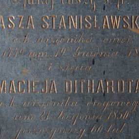 Zdjęcie nr 1: Epitafium w kształcie leżącego prostokąta. W jego polu biegnąca wzdłuż krawędzi opaska z wyciętymi narożami, w których rozety. W polu inskrypcja: „Spokój duszy ś(więtej) p(amięci) / TOMASZA STANISŁAWSKIEGO / c(esarsko) k(rólewskiego) urzędnika emer(ytowanego) / ur(odzonego) 1779. um(arłego) 19go Grudnia 1854. / i zięcia / MACIEJA DITHARDTA / c(esarsko) k(rólewskiego) urzędnika drogowego / um(arłego) 21. Sierpnia 1850. / przeżywszy 60. lat”.
