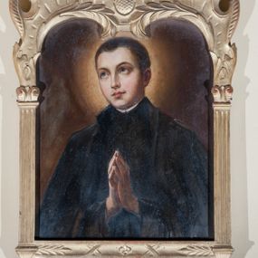 Zdjęcie nr 1: Obraz o prostokątnej, złotej ramie zakończonej półkoliście z ornamentem kartuszowym. Jego dolną krawędź zdobi fartuch z lambrekinem ozdobionym krzyżem, boki ujmują kanelowane pilastry z wolutowymi kapitelami dźwigającymi fantazyjne zwieńczenie z liśćmi i wolutami. Święty ukazany jest do pasa, frontalnie, z rękami złożonymi w geście modlitwy, z głową zwróconą w prawo. Jest ubrany w jezuicką sutannę i płaszcz, wokół głowy rozświetlona aureola. Twarz ma owalną, nos długi, oczy szeroko otwarte, uniesione ku górze, usta wąskie, pełne, a włosy czarne, krótkie. 