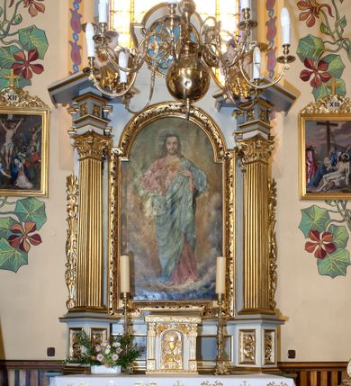 Zdjęcie nr 1: Ołtarz przyścienny, architektoniczny z murowaną mensą z kamiennym portatylem, antepedium z chrystogramem. Na mensie prostopadłościenne tabernakulum, ujęte pilastrami zwieńczonymi gzymsem, z drzwiczkami zakończonymi łukiem koszowym, na których kielich z hostią ujętą  kwiatami róż. Nastawa ołtarzowa jednokondygnacyjna, jednoosiowa ze zwieńczeniem. Retabulum ujęte parą kanelowanych filarów o korynckich głowicach, ustawionych na ukośnie dostawionych cokołach. Podpory ustawione na tle kanelowanych pilastrów wspierają ukośne odcinki belkowania zamknięte wydatnym gzymsem. Zwieńczenie o wklęsłych bokach, zamknięte łukiem nadwieszanym. 
Pole środkowe w formie prostokątnej wnęki z uskokiem u dołu, zamkniętej łukiem nadwieszonym. Wnęka ujęta ażurową ramą formowaną ze zwiniętych liści akantu, wewnątrz obraz z przedstawieniem Najświętszego Serca Jezusa. Antepedium drewniane, ujęte profilowaną ramą, pośrodku aplikowany hierogram. W zwieńczeniu medalion z rzeźbioną gołębicą Ducha świętego w promieniach. Pola cokołów zdobione płycinami ze zwiniętymi liśćmi akantu, w partii fryzu aplikowane rozety. Po bokach retabulum uszaki formowane z ornamentu kandelabrowego. Na gzymsie para rzeźbionych, uskrzydlonych aniołków. Całość struktury ołtarza malowana w odcieniach szarości, detal architektoniczny i profilowania pozłacane.
