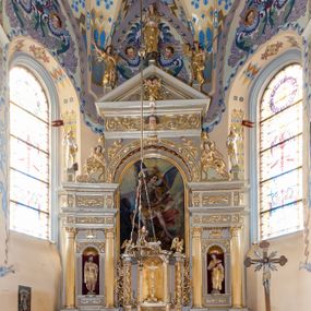 Zdjęcie nr 1: Nastawa ołtarzowa architektoniczna skomponowana na schemacie łuku triumfalnego, trójosiowa, jednokondygnacyjna ze zwieńczeniem. Ołtarz kamienny, licowany marmurowymi płytkami, z kamienną mensą. Oś środkowa jest dwukrotnie wyższa od bocznych i szersza, zamknięta półkoliście. Osie boczne ujęte dwiema parami pilastrów i stojących przed nimi kolumn o kanelowanych trzonach i kapitelach kompozytowych; między nimi nisze zwieńczone konchą z figurami św. Jana Chrzciciela i św. Jana Ewangelisty. Podpory dźwigają dwustrefowe belkowanie – niższe pełne, wyższe niepełne, delikatnie wyłamane na ich linii. Oś środkową ujmują woluty z figurami aniołów spływające na belkowanie osi bocznych; na skraju postumenty z figurami św. Floriana i św. Wacława(?). Postumenty kolumn dekorowane z trzech stron płycinami, od frontu z uskrzydlonymi główkami anielskimi; pomiędzy nimi rollwerki  z podpisami figur. Podłucze osi środkowej dekorowane kasetonami z rozetami; archiwolta wypełniona akantem, zwieńczona kluczem; w przyłuczach dwie płaskorzeźbione figury kobiece. Powyżej fryz dekorowany dużych rozmiarów uskrzydloną głową anielską, ujętą wicią roślinną, na gzymsie kartusz. W polu przyczółka roślinny postument podtrzymujący dwie uskrzydlone główki anielskie. W przyłuczach konch osi bocznych ornament roślinny, powyżej rauty, u spodu figur festony. Spód belkowania dekorowany kasetonami z rozetami. Fryzy dwóch stref belkowania wypełnione ornamentem roślinnym i rozetami; na wewnętrznym boku drugiej strefy para herbów Radwan. W polu środkowym obraz ukazujący Zwiastowanie Najświętszej Marii Panny, a na zasuwie Św. Michała Archanioła. Struktura polichromowana na szaro; kolumny, ornamentyka i profile złocone.
