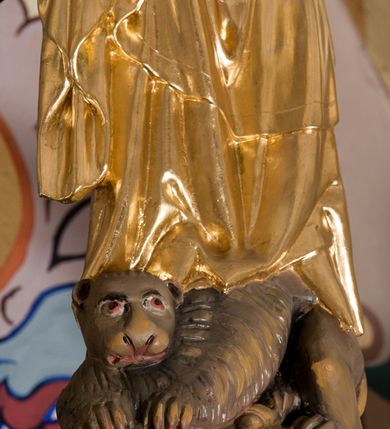 Zdjęcie nr 23: Nastawa ołtarzowa architektoniczna skomponowana na schemacie łuku triumfalnego, trójosiowa, jednokondygnacyjna ze zwieńczeniem. Ołtarz kamienny, licowany marmurowymi płytkami, z kamienną mensą. Oś środkowa jest dwukrotnie wyższa od bocznych i szersza, zamknięta półkoliście. Osie boczne ujęte dwiema parami pilastrów i stojących przed nimi kolumn o kanelowanych trzonach i kapitelach kompozytowych; między nimi nisze zwieńczone konchą z figurami św. Jana Chrzciciela i św. Jana Ewangelisty. Podpory dźwigają dwustrefowe belkowanie – niższe pełne, wyższe niepełne, delikatnie wyłamane na ich linii. Oś środkową ujmują woluty z figurami aniołów spływające na belkowanie osi bocznych; na skraju postumenty z figurami św. Floriana i św. Wacława(?). Postumenty kolumn dekorowane z trzech stron płycinami, od frontu z uskrzydlonymi główkami anielskimi; pomiędzy nimi rollwerki  z podpisami figur. Podłucze osi środkowej dekorowane kasetonami z rozetami; archiwolta wypełniona akantem, zwieńczona kluczem; w przyłuczach dwie płaskorzeźbione figury kobiece. Powyżej fryz dekorowany dużych rozmiarów uskrzydloną głową anielską, ujętą wicią roślinną, na gzymsie kartusz. W polu przyczółka roślinny postument podtrzymujący dwie uskrzydlone główki anielskie. W przyłuczach konch osi bocznych ornament roślinny, powyżej rauty, u spodu figur festony. Spód belkowania dekorowany kasetonami z rozetami. Fryzy dwóch stref belkowania wypełnione ornamentem roślinnym i rozetami; na wewnętrznym boku drugiej strefy para herbów Radwan. W polu środkowym obraz ukazujący Zwiastowanie Najświętszej Marii Panny, a na zasuwie Św. Michała Archanioła. Struktura polichromowana na szaro; kolumny, ornamentyka i profile złocone.
