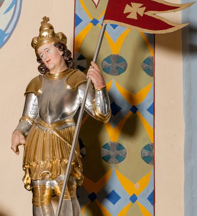 Zdjęcie nr 20: Nastawa ołtarzowa architektoniczna skomponowana na schemacie łuku triumfalnego, trójosiowa, jednokondygnacyjna ze zwieńczeniem. Ołtarz kamienny, licowany marmurowymi płytkami, z kamienną mensą. Oś środkowa jest dwukrotnie wyższa od bocznych i szersza, zamknięta półkoliście. Osie boczne ujęte dwiema parami pilastrów i stojących przed nimi kolumn o kanelowanych trzonach i kapitelach kompozytowych; między nimi nisze zwieńczone konchą z figurami św. Jana Chrzciciela i św. Jana Ewangelisty. Podpory dźwigają dwustrefowe belkowanie – niższe pełne, wyższe niepełne, delikatnie wyłamane na ich linii. Oś środkową ujmują woluty z figurami aniołów spływające na belkowanie osi bocznych; na skraju postumenty z figurami św. Floriana i św. Wacława(?). Postumenty kolumn dekorowane z trzech stron płycinami, od frontu z uskrzydlonymi główkami anielskimi; pomiędzy nimi rollwerki  z podpisami figur. Podłucze osi środkowej dekorowane kasetonami z rozetami; archiwolta wypełniona akantem, zwieńczona kluczem; w przyłuczach dwie płaskorzeźbione figury kobiece. Powyżej fryz dekorowany dużych rozmiarów uskrzydloną głową anielską, ujętą wicią roślinną, na gzymsie kartusz. W polu przyczółka roślinny postument podtrzymujący dwie uskrzydlone główki anielskie. W przyłuczach konch osi bocznych ornament roślinny, powyżej rauty, u spodu figur festony. Spód belkowania dekorowany kasetonami z rozetami. Fryzy dwóch stref belkowania wypełnione ornamentem roślinnym i rozetami; na wewnętrznym boku drugiej strefy para herbów Radwan. W polu środkowym obraz ukazujący Zwiastowanie Najświętszej Marii Panny, a na zasuwie Św. Michała Archanioła. Struktura polichromowana na szaro; kolumny, ornamentyka i profile złocone.

