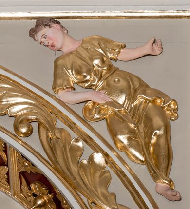 Zdjęcie nr 37: Nastawa ołtarzowa architektoniczna skomponowana na schemacie łuku triumfalnego, trójosiowa, jednokondygnacyjna ze zwieńczeniem. Ołtarz kamienny, licowany marmurowymi płytkami, z kamienną mensą. Oś środkowa jest dwukrotnie wyższa od bocznych i szersza, zamknięta półkoliście. Osie boczne ujęte dwiema parami pilastrów i stojących przed nimi kolumn o kanelowanych trzonach i kapitelach kompozytowych; między nimi nisze zwieńczone konchą z figurami św. Jana Chrzciciela i św. Jana Ewangelisty. Podpory dźwigają dwustrefowe belkowanie – niższe pełne, wyższe niepełne, delikatnie wyłamane na ich linii. Oś środkową ujmują woluty z figurami aniołów spływające na belkowanie osi bocznych; na skraju postumenty z figurami św. Floriana i św. Wacława(?). Postumenty kolumn dekorowane z trzech stron płycinami, od frontu z uskrzydlonymi główkami anielskimi; pomiędzy nimi rollwerki  z podpisami figur. Podłucze osi środkowej dekorowane kasetonami z rozetami; archiwolta wypełniona akantem, zwieńczona kluczem; w przyłuczach dwie płaskorzeźbione figury kobiece. Powyżej fryz dekorowany dużych rozmiarów uskrzydloną głową anielską, ujętą wicią roślinną, na gzymsie kartusz. W polu przyczółka roślinny postument podtrzymujący dwie uskrzydlone główki anielskie. W przyłuczach konch osi bocznych ornament roślinny, powyżej rauty, u spodu figur festony. Spód belkowania dekorowany kasetonami z rozetami. Fryzy dwóch stref belkowania wypełnione ornamentem roślinnym i rozetami; na wewnętrznym boku drugiej strefy para herbów Radwan. W polu środkowym obraz ukazujący Zwiastowanie Najświętszej Marii Panny, a na zasuwie Św. Michała Archanioła. Struktura polichromowana na szaro; kolumny, ornamentyka i profile złocone.
