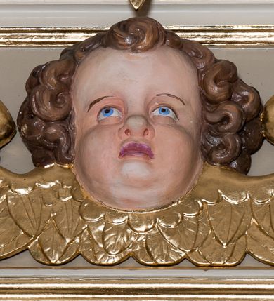 Zdjęcie nr 35: Nastawa ołtarzowa architektoniczna skomponowana na schemacie łuku triumfalnego, trójosiowa, jednokondygnacyjna ze zwieńczeniem. Ołtarz kamienny, licowany marmurowymi płytkami, z kamienną mensą. Oś środkowa jest dwukrotnie wyższa od bocznych i szersza, zamknięta półkoliście. Osie boczne ujęte dwiema parami pilastrów i stojących przed nimi kolumn o kanelowanych trzonach i kapitelach kompozytowych; między nimi nisze zwieńczone konchą z figurami św. Jana Chrzciciela i św. Jana Ewangelisty. Podpory dźwigają dwustrefowe belkowanie – niższe pełne, wyższe niepełne, delikatnie wyłamane na ich linii. Oś środkową ujmują woluty z figurami aniołów spływające na belkowanie osi bocznych; na skraju postumenty z figurami św. Floriana i św. Wacława(?). Postumenty kolumn dekorowane z trzech stron płycinami, od frontu z uskrzydlonymi główkami anielskimi; pomiędzy nimi rollwerki  z podpisami figur. Podłucze osi środkowej dekorowane kasetonami z rozetami; archiwolta wypełniona akantem, zwieńczona kluczem; w przyłuczach dwie płaskorzeźbione figury kobiece. Powyżej fryz dekorowany dużych rozmiarów uskrzydloną głową anielską, ujętą wicią roślinną, na gzymsie kartusz. W polu przyczółka roślinny postument podtrzymujący dwie uskrzydlone główki anielskie. W przyłuczach konch osi bocznych ornament roślinny, powyżej rauty, u spodu figur festony. Spód belkowania dekorowany kasetonami z rozetami. Fryzy dwóch stref belkowania wypełnione ornamentem roślinnym i rozetami; na wewnętrznym boku drugiej strefy para herbów Radwan. W polu środkowym obraz ukazujący Zwiastowanie Najświętszej Marii Panny, a na zasuwie Św. Michała Archanioła. Struktura polichromowana na szaro; kolumny, ornamentyka i profile złocone.
