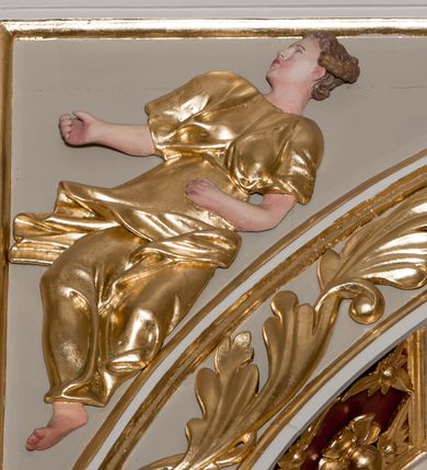 Zdjęcie nr 38: Nastawa ołtarzowa architektoniczna skomponowana na schemacie łuku triumfalnego, trójosiowa, jednokondygnacyjna ze zwieńczeniem. Ołtarz kamienny, licowany marmurowymi płytkami, z kamienną mensą. Oś środkowa jest dwukrotnie wyższa od bocznych i szersza, zamknięta półkoliście. Osie boczne ujęte dwiema parami pilastrów i stojących przed nimi kolumn o kanelowanych trzonach i kapitelach kompozytowych; między nimi nisze zwieńczone konchą z figurami św. Jana Chrzciciela i św. Jana Ewangelisty. Podpory dźwigają dwustrefowe belkowanie – niższe pełne, wyższe niepełne, delikatnie wyłamane na ich linii. Oś środkową ujmują woluty z figurami aniołów spływające na belkowanie osi bocznych; na skraju postumenty z figurami św. Floriana i św. Wacława(?). Postumenty kolumn dekorowane z trzech stron płycinami, od frontu z uskrzydlonymi główkami anielskimi; pomiędzy nimi rollwerki  z podpisami figur. Podłucze osi środkowej dekorowane kasetonami z rozetami; archiwolta wypełniona akantem, zwieńczona kluczem; w przyłuczach dwie płaskorzeźbione figury kobiece. Powyżej fryz dekorowany dużych rozmiarów uskrzydloną głową anielską, ujętą wicią roślinną, na gzymsie kartusz. W polu przyczółka roślinny postument podtrzymujący dwie uskrzydlone główki anielskie. W przyłuczach konch osi bocznych ornament roślinny, powyżej rauty, u spodu figur festony. Spód belkowania dekorowany kasetonami z rozetami. Fryzy dwóch stref belkowania wypełnione ornamentem roślinnym i rozetami; na wewnętrznym boku drugiej strefy para herbów Radwan. W polu środkowym obraz ukazujący Zwiastowanie Najświętszej Marii Panny, a na zasuwie Św. Michała Archanioła. Struktura polichromowana na szaro; kolumny, ornamentyka i profile złocone.
