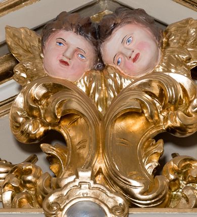 Zdjęcie nr 36: Nastawa ołtarzowa architektoniczna skomponowana na schemacie łuku triumfalnego, trójosiowa, jednokondygnacyjna ze zwieńczeniem. Ołtarz kamienny, licowany marmurowymi płytkami, z kamienną mensą. Oś środkowa jest dwukrotnie wyższa od bocznych i szersza, zamknięta półkoliście. Osie boczne ujęte dwiema parami pilastrów i stojących przed nimi kolumn o kanelowanych trzonach i kapitelach kompozytowych; między nimi nisze zwieńczone konchą z figurami św. Jana Chrzciciela i św. Jana Ewangelisty. Podpory dźwigają dwustrefowe belkowanie – niższe pełne, wyższe niepełne, delikatnie wyłamane na ich linii. Oś środkową ujmują woluty z figurami aniołów spływające na belkowanie osi bocznych; na skraju postumenty z figurami św. Floriana i św. Wacława(?). Postumenty kolumn dekorowane z trzech stron płycinami, od frontu z uskrzydlonymi główkami anielskimi; pomiędzy nimi rollwerki  z podpisami figur. Podłucze osi środkowej dekorowane kasetonami z rozetami; archiwolta wypełniona akantem, zwieńczona kluczem; w przyłuczach dwie płaskorzeźbione figury kobiece. Powyżej fryz dekorowany dużych rozmiarów uskrzydloną głową anielską, ujętą wicią roślinną, na gzymsie kartusz. W polu przyczółka roślinny postument podtrzymujący dwie uskrzydlone główki anielskie. W przyłuczach konch osi bocznych ornament roślinny, powyżej rauty, u spodu figur festony. Spód belkowania dekorowany kasetonami z rozetami. Fryzy dwóch stref belkowania wypełnione ornamentem roślinnym i rozetami; na wewnętrznym boku drugiej strefy para herbów Radwan. W polu środkowym obraz ukazujący Zwiastowanie Najświętszej Marii Panny, a na zasuwie Św. Michała Archanioła. Struktura polichromowana na szaro; kolumny, ornamentyka i profile złocone.
