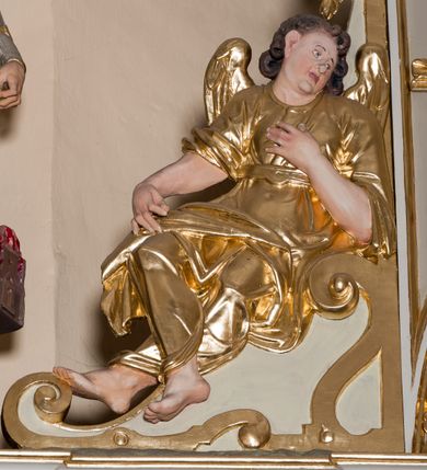 Zdjęcie nr 39: Nastawa ołtarzowa architektoniczna skomponowana na schemacie łuku triumfalnego, trójosiowa, jednokondygnacyjna ze zwieńczeniem. Ołtarz kamienny, licowany marmurowymi płytkami, z kamienną mensą. Oś środkowa jest dwukrotnie wyższa od bocznych i szersza, zamknięta półkoliście. Osie boczne ujęte dwiema parami pilastrów i stojących przed nimi kolumn o kanelowanych trzonach i kapitelach kompozytowych; między nimi nisze zwieńczone konchą z figurami św. Jana Chrzciciela i św. Jana Ewangelisty. Podpory dźwigają dwustrefowe belkowanie – niższe pełne, wyższe niepełne, delikatnie wyłamane na ich linii. Oś środkową ujmują woluty z figurami aniołów spływające na belkowanie osi bocznych; na skraju postumenty z figurami św. Floriana i św. Wacława(?). Postumenty kolumn dekorowane z trzech stron płycinami, od frontu z uskrzydlonymi główkami anielskimi; pomiędzy nimi rollwerki  z podpisami figur. Podłucze osi środkowej dekorowane kasetonami z rozetami; archiwolta wypełniona akantem, zwieńczona kluczem; w przyłuczach dwie płaskorzeźbione figury kobiece. Powyżej fryz dekorowany dużych rozmiarów uskrzydloną głową anielską, ujętą wicią roślinną, na gzymsie kartusz. W polu przyczółka roślinny postument podtrzymujący dwie uskrzydlone główki anielskie. W przyłuczach konch osi bocznych ornament roślinny, powyżej rauty, u spodu figur festony. Spód belkowania dekorowany kasetonami z rozetami. Fryzy dwóch stref belkowania wypełnione ornamentem roślinnym i rozetami; na wewnętrznym boku drugiej strefy para herbów Radwan. W polu środkowym obraz ukazujący Zwiastowanie Najświętszej Marii Panny, a na zasuwie Św. Michała Archanioła. Struktura polichromowana na szaro; kolumny, ornamentyka i profile złocone.
