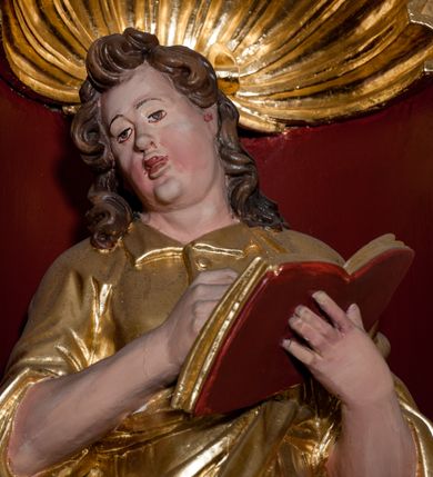 Zdjęcie nr 41: Nastawa ołtarzowa architektoniczna skomponowana na schemacie łuku triumfalnego, trójosiowa, jednokondygnacyjna ze zwieńczeniem. Ołtarz kamienny, licowany marmurowymi płytkami, z kamienną mensą. Oś środkowa jest dwukrotnie wyższa od bocznych i szersza, zamknięta półkoliście. Osie boczne ujęte dwiema parami pilastrów i stojących przed nimi kolumn o kanelowanych trzonach i kapitelach kompozytowych; między nimi nisze zwieńczone konchą z figurami św. Jana Chrzciciela i św. Jana Ewangelisty. Podpory dźwigają dwustrefowe belkowanie – niższe pełne, wyższe niepełne, delikatnie wyłamane na ich linii. Oś środkową ujmują woluty z figurami aniołów spływające na belkowanie osi bocznych; na skraju postumenty z figurami św. Floriana i św. Wacława(?). Postumenty kolumn dekorowane z trzech stron płycinami, od frontu z uskrzydlonymi główkami anielskimi; pomiędzy nimi rollwerki  z podpisami figur. Podłucze osi środkowej dekorowane kasetonami z rozetami; archiwolta wypełniona akantem, zwieńczona kluczem; w przyłuczach dwie płaskorzeźbione figury kobiece. Powyżej fryz dekorowany dużych rozmiarów uskrzydloną głową anielską, ujętą wicią roślinną, na gzymsie kartusz. W polu przyczółka roślinny postument podtrzymujący dwie uskrzydlone główki anielskie. W przyłuczach konch osi bocznych ornament roślinny, powyżej rauty, u spodu figur festony. Spód belkowania dekorowany kasetonami z rozetami. Fryzy dwóch stref belkowania wypełnione ornamentem roślinnym i rozetami; na wewnętrznym boku drugiej strefy para herbów Radwan. W polu środkowym obraz ukazujący Zwiastowanie Najświętszej Marii Panny, a na zasuwie Św. Michała Archanioła. Struktura polichromowana na szaro; kolumny, ornamentyka i profile złocone.
