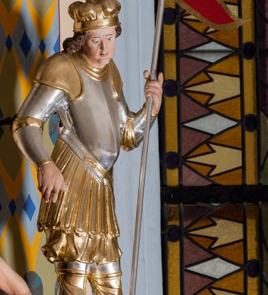 Zdjęcie nr 48: Nastawa ołtarzowa architektoniczna skomponowana na schemacie łuku triumfalnego, trójosiowa, jednokondygnacyjna ze zwieńczeniem. Ołtarz kamienny, licowany marmurowymi płytkami, z kamienną mensą. Oś środkowa jest dwukrotnie wyższa od bocznych i szersza, zamknięta półkoliście. Osie boczne ujęte dwiema parami pilastrów i stojących przed nimi kolumn o kanelowanych trzonach i kapitelach kompozytowych; między nimi nisze zwieńczone konchą z figurami św. Jana Chrzciciela i św. Jana Ewangelisty. Podpory dźwigają dwustrefowe belkowanie – niższe pełne, wyższe niepełne, delikatnie wyłamane na ich linii. Oś środkową ujmują woluty z figurami aniołów spływające na belkowanie osi bocznych; na skraju postumenty z figurami św. Floriana i św. Wacława(?). Postumenty kolumn dekorowane z trzech stron płycinami, od frontu z uskrzydlonymi główkami anielskimi; pomiędzy nimi rollwerki  z podpisami figur. Podłucze osi środkowej dekorowane kasetonami z rozetami; archiwolta wypełniona akantem, zwieńczona kluczem; w przyłuczach dwie płaskorzeźbione figury kobiece. Powyżej fryz dekorowany dużych rozmiarów uskrzydloną głową anielską, ujętą wicią roślinną, na gzymsie kartusz. W polu przyczółka roślinny postument podtrzymujący dwie uskrzydlone główki anielskie. W przyłuczach konch osi bocznych ornament roślinny, powyżej rauty, u spodu figur festony. Spód belkowania dekorowany kasetonami z rozetami. Fryzy dwóch stref belkowania wypełnione ornamentem roślinnym i rozetami; na wewnętrznym boku drugiej strefy para herbów Radwan. W polu środkowym obraz ukazujący Zwiastowanie Najświętszej Marii Panny, a na zasuwie Św. Michała Archanioła. Struktura polichromowana na szaro; kolumny, ornamentyka i profile złocone.
