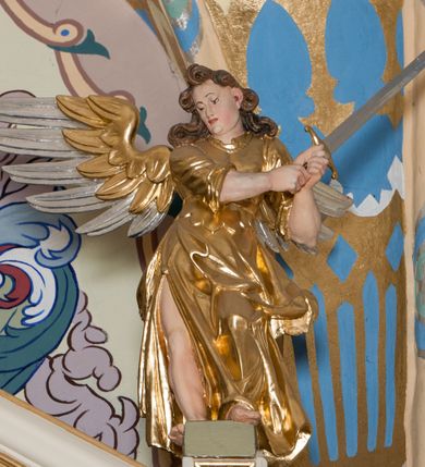 Zdjęcie nr 50: Nastawa ołtarzowa architektoniczna skomponowana na schemacie łuku triumfalnego, trójosiowa, jednokondygnacyjna ze zwieńczeniem. Ołtarz kamienny, licowany marmurowymi płytkami, z kamienną mensą. Oś środkowa jest dwukrotnie wyższa od bocznych i szersza, zamknięta półkoliście. Osie boczne ujęte dwiema parami pilastrów i stojących przed nimi kolumn o kanelowanych trzonach i kapitelach kompozytowych; między nimi nisze zwieńczone konchą z figurami św. Jana Chrzciciela i św. Jana Ewangelisty. Podpory dźwigają dwustrefowe belkowanie – niższe pełne, wyższe niepełne, delikatnie wyłamane na ich linii. Oś środkową ujmują woluty z figurami aniołów spływające na belkowanie osi bocznych; na skraju postumenty z figurami św. Floriana i św. Wacława(?). Postumenty kolumn dekorowane z trzech stron płycinami, od frontu z uskrzydlonymi główkami anielskimi; pomiędzy nimi rollwerki  z podpisami figur. Podłucze osi środkowej dekorowane kasetonami z rozetami; archiwolta wypełniona akantem, zwieńczona kluczem; w przyłuczach dwie płaskorzeźbione figury kobiece. Powyżej fryz dekorowany dużych rozmiarów uskrzydloną głową anielską, ujętą wicią roślinną, na gzymsie kartusz. W polu przyczółka roślinny postument podtrzymujący dwie uskrzydlone główki anielskie. W przyłuczach konch osi bocznych ornament roślinny, powyżej rauty, u spodu figur festony. Spód belkowania dekorowany kasetonami z rozetami. Fryzy dwóch stref belkowania wypełnione ornamentem roślinnym i rozetami; na wewnętrznym boku drugiej strefy para herbów Radwan. W polu środkowym obraz ukazujący Zwiastowanie Najświętszej Marii Panny, a na zasuwie Św. Michała Archanioła. Struktura polichromowana na szaro; kolumny, ornamentyka i profile złocone.
