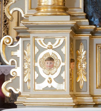 Zdjęcie nr 4: Ołtarz architektoniczny, jednoosiowy, jednokondygnacyjny ze zwieńczeniem. Antepedium z prostokątną ramą o ćwierćkoliście wyciętych narożach z promienimi i monogramem MARIA. Na mensie prostopadłościenne tabernakulum z drzwiczkami wypełnionymi płaskorzeźbionym barankiem apokaliptycznym. Wokół drzwiczek winna latorośl a w narożach uskrzydlone główki aniołków. Kompozycja nastawy wykorzystuje schemat łuku triumfalnego z arkadą zamknietą półkoliście flankowaną kolumnami stojącymi na postumentach, z kompozytowymi kapitelami dźwigającymi belkowanie. Nad belkowaniem przerwany i wyłamujący się ponad kolumnami, segmentowy przyczółek. W arkadzie obraz z Matką Boską Różąńcową ze św. Katarzyną Sieneńską i św. Dominikiem. Na zwieńczeniu dwie siedzące figury Ewangelistów (?), brodatych, ubranych w długie suknie i płaszcze, z otwartą księgą i piórem w dłoniach. W partii przerwanego przyczółka stoi na postumencie anioł z rozwartymi rękami, ubrany w długą suknię, z rozpostartymi skrzydłami. 
Cokoły zdobią motywy okuciowe z główkami aniołów. Kolumny w jednej trzeciej ujęte profilowaniem, w dolnej pokryte są okuciowymi taśmami i główkami aniołków, a w górnej wijącą się spiralnie wicią roślinną. Boki nastawy ujmują uszy utworzone z zawijających się taśm. Nad niszą z obrazem główki aniołków. Profile belkowania ozdobione konsolkami i kostkowaniem a fryz wicią roślinną i medalionem z literami IHS. Podobne ornamenty w partii przyczółka. Kolorystyka ołtarza jest szara, kolumny, profile, złocone i srebrzone, twarze aniołków i postaci w zwieńczeniu polichromowane naturalistycznie.  
