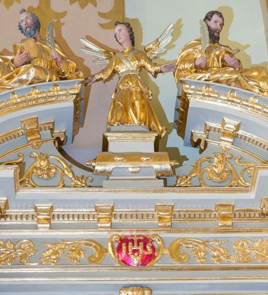 Zdjęcie nr 6: Ołtarz architektoniczny, jednoosiowy, jednokondygnacyjny ze zwieńczeniem. Antepedium z prostokątną ramą o ćwierćkoliście wyciętych narożach z promienimi i monogramem MARIA. Na mensie prostopadłościenne tabernakulum z drzwiczkami wypełnionymi płaskorzeźbionym barankiem apokaliptycznym. Wokół drzwiczek winna latorośl a w narożach uskrzydlone główki aniołków. Kompozycja nastawy wykorzystuje schemat łuku triumfalnego z arkadą zamknietą półkoliście flankowaną kolumnami stojącymi na postumentach, z kompozytowymi kapitelami dźwigającymi belkowanie. Nad belkowaniem przerwany i wyłamujący się ponad kolumnami, segmentowy przyczółek. W arkadzie obraz z Matką Boską Różąńcową ze św. Katarzyną Sieneńską i św. Dominikiem. Na zwieńczeniu dwie siedzące figury Ewangelistów (?), brodatych, ubranych w długie suknie i płaszcze, z otwartą księgą i piórem w dłoniach. W partii przerwanego przyczółka stoi na postumencie anioł z rozwartymi rękami, ubrany w długą suknię, z rozpostartymi skrzydłami. 
Cokoły zdobią motywy okuciowe z główkami aniołów. Kolumny w jednej trzeciej ujęte profilowaniem, w dolnej pokryte są okuciowymi taśmami i główkami aniołków, a w górnej wijącą się spiralnie wicią roślinną. Boki nastawy ujmują uszy utworzone z zawijających się taśm. Nad niszą z obrazem główki aniołków. Profile belkowania ozdobione konsolkami i kostkowaniem a fryz wicią roślinną i medalionem z literami IHS. Podobne ornamenty w partii przyczółka. Kolorystyka ołtarza jest szara, kolumny, profile, złocone i srebrzone, twarze aniołków i postaci w zwieńczeniu polichromowane naturalistycznie.  
