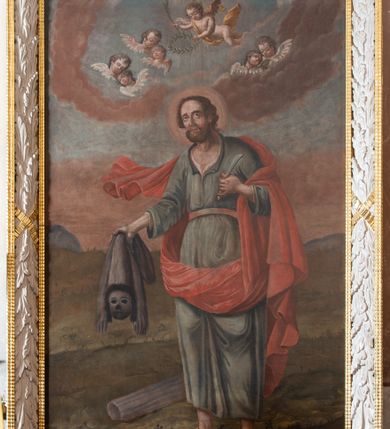 Zdjęcie nr 3: Obraz w kształcie stojącego prostokąta. Kompozycja dwustrefowa. Święty Bartłomiej Apostoł ukazany w całej postaci, en trois quatre, zwrócony lekko w prawo. Stoi na murawie, z rękami ugiętymi w łokciach, trzymając w dłoniach nóż (w lewej) oraz swoją skórę (w prawej). Lekko przygarbiona sylwetka i twarz z wysokim czołem, okolona kędzierzawymi włosami i zarostem wskazują na dojrzały wiek świętego. Wokół głowy złoty nimb. Ubrany w długą niemal do kostek suknię z długimi szerokimi rękawami, z rozcięciem na piersi, przewiązaną w pasie. Okryty jest czerwoną draperią, której konie powiewa na wietrze po prawej stronie świętego. Na stopach nosi sandały z rzemyków. W tle zielona murawa z trzonem kanelowanej kolumny oraz niebo ponad linią dalekiego horyzontu. W strefie górnej wśród obłoków pary główek aniołków ze skrzydełkami oraz pośrodku kompozycji, nad głową świętego Bartłomieja, lecące na skrzydłach putto z palmą męczeńską w prawej ręce. Kolorstyka stonowana, skontrastowana z czerwoną draperią.  