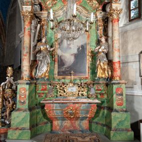 Zdjęcie nr 1: Ołtarz na rzucie połowy owalu, architektoniczny, kulisowy, jednokondygnacyjny, jednoosiowy, ze zwieńczeniem. Drewniana mensa ołtarza (późniejsza) oparta na skrzyni o formie tumby z wydzielonym cokołem. Retabulum na wysokim potrójnym, cokole, ujęte parą ukośnie ustawionych konsol o formie wolut, na których ustawione rzeźby, oraz parą odsuniętych od lica części środkowej kolumn o gładkich trzonach i kompozytowych kapitelach, wspierających przerwane belkowanie i gzyms. Pole środkowe ujęte pilastrami o wolutowych kapitelach, zwieńczone gzymsem wygiętym łukiem wklęsło-wypukłym. Pośrodku pola profilowana rama zamknięta łukiem wklęsło-wypukłym nadwieszonym, na obraz ołtarzowy. Zwieńczenie o dekoracyjnym wykroju linią wklęsło-wypukłą, z wysuniętymi na kolumny spływami wolutowymi.  Pośrodku zwieńczenia profilowana rama w kształcie stojącego owalu. Antepedium, część środkowa retabulum oraz zwieńczenie zdobione motywami ornamentów rokokowych. Retabulum ujęte parą ażurowych, rokokowych uszaków. W płycinach na spływach motywy roślinne i rozetki. Pośrodku gzymsu wieńczącego część środkową retabulum kartusz ujęty ornamentem rokokowym. W zwieńczeniu, na gzymsie, po bokach para wazonów z kwiatami, szczyt z dekoracją roccaillową. W polu środkowym obraz Objawienie się Chrystusa św. Małgorzacie Alacoque. Na wolutowych konsolach po bokach rzeźby św. Apolonii po lewej i św. Rozalii z Palermo po prawej stronie. W zwieńczeniu malowane ozdobne litery IHS z krzyżem, ujęte promienistą glorią oraz koroną cierniową. W osiach kolumn na spływach wolutowych zwieńczenia para aniołków. Na mensie trzy kanony ołtarzowe ujęte ażurowymi ramami ze stylizowanych wici akantu, zdobione rozetami. Struktura ołtarza w całości marmoryzowana, kolorystyka w odcieniach zieleni, beżów, czerwieni i niebieskim. Fragmenty detalu architektonicznego i ornamenty złocone i srebrzone. 