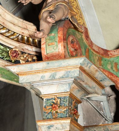 Zdjęcie nr 16: Ołtarz na rzucie połowy owalu, architektoniczny, kulisowy, jednokondygnacyjny, jednoosiowy, ze zwieńczeniem. Drewniana mensa ołtarza (późniejsza) oparta na skrzyni o formie tumby z wydzielonym cokołem. Retabulum na wysokim potrójnym, cokole, ujęte parą ukośnie ustawionych konsol o formie wolut, na których ustawione rzeźby, oraz parą odsuniętych od lica części środkowej kolumn o gładkich trzonach i kompozytowych kapitelach, wspierających przerwane belkowanie i gzyms. Pole środkowe ujęte pilastrami o wolutowych kapitelach, zwieńczone gzymsem wygiętym łukiem wklęsło-wypukłym. Pośrodku pola profilowana rama zamknięta łukiem wklęsło-wypukłym nadwieszonym, na obraz ołtarzowy. Zwieńczenie o dekoracyjnym wykroju linią wklęsło-wypukłą, z wysuniętymi na kolumny spływami wolutowymi.  Pośrodku zwieńczenia profilowana rama w kształcie stojącego owalu. Antepedium, część środkowa retabulum oraz zwieńczenie zdobione motywami ornamentów rokokowych. Retabulum ujęte parą ażurowych, rokokowych uszaków. W płycinach na spływach motywy roślinne i rozetki. Pośrodku gzymsu wieńczącego część środkową retabulum kartusz ujęty ornamentem rokokowym. W zwieńczeniu, na gzymsie, po bokach para wazonów z kwiatami, szczyt z dekoracją roccaillową. W polu środkowym obraz Objawienie się Chrystusa św. Małgorzacie Alacoque. Na wolutowych konsolach po bokach rzeźby św. Apolonii po lewej i św. Rozalii z Palermo po prawej stronie. W zwieńczeniu malowane ozdobne litery IHS z krzyżem, ujęte promienistą glorią oraz koroną cierniową. W osiach kolumn na spływach wolutowych zwieńczenia para aniołków. Na mensie trzy kanony ołtarzowe ujęte ażurowymi ramami ze stylizowanych wici akantu, zdobione rozetami. Struktura ołtarza w całości marmoryzowana, kolorystyka w odcieniach zieleni, beżów, czerwieni i niebieskim. Fragmenty detalu architektonicznego i ornamenty złocone i srebrzone. 
