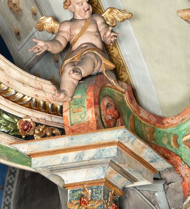 Zdjęcie nr 15: Ołtarz na rzucie połowy owalu, architektoniczny, kulisowy, jednokondygnacyjny, jednoosiowy, ze zwieńczeniem. Drewniana mensa ołtarza (późniejsza) oparta na skrzyni o formie tumby z wydzielonym cokołem. Retabulum na wysokim potrójnym, cokole, ujęte parą ukośnie ustawionych konsol o formie wolut, na których ustawione rzeźby, oraz parą odsuniętych od lica części środkowej kolumn o gładkich trzonach i kompozytowych kapitelach, wspierających przerwane belkowanie i gzyms. Pole środkowe ujęte pilastrami o wolutowych kapitelach, zwieńczone gzymsem wygiętym łukiem wklęsło-wypukłym. Pośrodku pola profilowana rama zamknięta łukiem wklęsło-wypukłym nadwieszonym, na obraz ołtarzowy. Zwieńczenie o dekoracyjnym wykroju linią wklęsło-wypukłą, z wysuniętymi na kolumny spływami wolutowymi.  Pośrodku zwieńczenia profilowana rama w kształcie stojącego owalu. Antepedium, część środkowa retabulum oraz zwieńczenie zdobione motywami ornamentów rokokowych. Retabulum ujęte parą ażurowych, rokokowych uszaków. W płycinach na spływach motywy roślinne i rozetki. Pośrodku gzymsu wieńczącego część środkową retabulum kartusz ujęty ornamentem rokokowym. W zwieńczeniu, na gzymsie, po bokach para wazonów z kwiatami, szczyt z dekoracją roccaillową. W polu środkowym obraz Objawienie się Chrystusa św. Małgorzacie Alacoque. Na wolutowych konsolach po bokach rzeźby św. Apolonii po lewej i św. Rozalii z Palermo po prawej stronie. W zwieńczeniu malowane ozdobne litery IHS z krzyżem, ujęte promienistą glorią oraz koroną cierniową. W osiach kolumn na spływach wolutowych zwieńczenia para aniołków. Na mensie trzy kanony ołtarzowe ujęte ażurowymi ramami ze stylizowanych wici akantu, zdobione rozetami. Struktura ołtarza w całości marmoryzowana, kolorystyka w odcieniach zieleni, beżów, czerwieni i niebieskim. Fragmenty detalu architektonicznego i ornamenty złocone i srebrzone. 