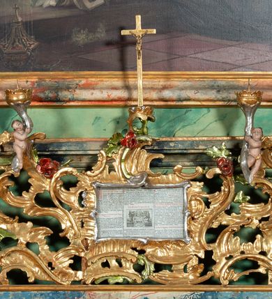 Zdjęcie nr 4: Ołtarz na rzucie połowy owalu, architektoniczny, kulisowy, jednokondygnacyjny, jednoosiowy, ze zwieńczeniem. Drewniana mensa ołtarza (późniejsza) oparta na skrzyni o formie tumby z wydzielonym cokołem. Retabulum na wysokim potrójnym, cokole, ujęte parą ukośnie ustawionych konsol o formie wolut, na których ustawione rzeźby, oraz parą odsuniętych od lica części środkowej kolumn o gładkich trzonach i kompozytowych kapitelach, wspierających przerwane belkowanie i gzyms. Pole środkowe ujęte pilastrami o wolutowych kapitelach, zwieńczone gzymsem wygiętym łukiem wklęsło-wypukłym. Pośrodku pola profilowana rama zamknięta łukiem wklęsło-wypukłym nadwieszonym, na obraz ołtarzowy. Zwieńczenie o dekoracyjnym wykroju linią wklęsło-wypukłą, z wysuniętymi na kolumny spływami wolutowymi.  Pośrodku zwieńczenia profilowana rama w kształcie stojącego owalu. Antepedium, część środkowa retabulum oraz zwieńczenie zdobione motywami ornamentów rokokowych. Retabulum ujęte parą ażurowych, rokokowych uszaków. W płycinach na spływach motywy roślinne i rozetki. Pośrodku gzymsu wieńczącego część środkową retabulum kartusz ujęty ornamentem rokokowym. W zwieńczeniu, na gzymsie, po bokach para wazonów z kwiatami, szczyt z dekoracją roccaillową. W polu środkowym obraz Objawienie się Chrystusa św. Małgorzacie Alacoque. Na wolutowych konsolach po bokach rzeźby św. Apolonii po lewej i św. Rozalii z Palermo po prawej stronie. W zwieńczeniu malowane ozdobne litery IHS z krzyżem, ujęte promienistą glorią oraz koroną cierniową. W osiach kolumn na spływach wolutowych zwieńczenia para aniołków. Na mensie trzy kanony ołtarzowe ujęte ażurowymi ramami ze stylizowanych wici akantu, zdobione rozetami. Struktura ołtarza w całości marmoryzowana, kolorystyka w odcieniach zieleni, beżów, czerwieni i niebieskim. Fragmenty detalu architektonicznego i ornamenty złocone i srebrzone. 