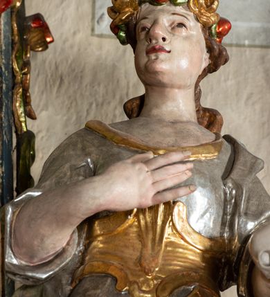 Zdjęcie nr 6: Ołtarz na rzucie połowy owalu, architektoniczny, kulisowy, jednokondygnacyjny, jednoosiowy, ze zwieńczeniem. Drewniana mensa ołtarza (późniejsza) oparta na skrzyni o formie tumby z wydzielonym cokołem. Retabulum na wysokim potrójnym, cokole, ujęte parą ukośnie ustawionych konsol o formie wolut, na których ustawione rzeźby, oraz parą odsuniętych od lica części środkowej kolumn o gładkich trzonach i kompozytowych kapitelach, wspierających przerwane belkowanie i gzyms. Pole środkowe ujęte pilastrami o wolutowych kapitelach, zwieńczone gzymsem wygiętym łukiem wklęsło-wypukłym. Pośrodku pola profilowana rama zamknięta łukiem wklęsło-wypukłym nadwieszonym, na obraz ołtarzowy. Zwieńczenie o dekoracyjnym wykroju linią wklęsło-wypukłą, z wysuniętymi na kolumny spływami wolutowymi.  Pośrodku zwieńczenia profilowana rama w kształcie stojącego owalu. Antepedium, część środkowa retabulum oraz zwieńczenie zdobione motywami ornamentów rokokowych. Retabulum ujęte parą ażurowych, rokokowych uszaków. W płycinach na spływach motywy roślinne i rozetki. Pośrodku gzymsu wieńczącego część środkową retabulum kartusz ujęty ornamentem rokokowym. W zwieńczeniu, na gzymsie, po bokach para wazonów z kwiatami, szczyt z dekoracją roccaillową. W polu środkowym obraz Objawienie się Chrystusa św. Małgorzacie Alacoque. Na wolutowych konsolach po bokach rzeźby św. Apolonii po lewej i św. Rozalii z Palermo po prawej stronie. W zwieńczeniu malowane ozdobne litery IHS z krzyżem, ujęte promienistą glorią oraz koroną cierniową. W osiach kolumn na spływach wolutowych zwieńczenia para aniołków. Na mensie trzy kanony ołtarzowe ujęte ażurowymi ramami ze stylizowanych wici akantu, zdobione rozetami. Struktura ołtarza w całości marmoryzowana, kolorystyka w odcieniach zieleni, beżów, czerwieni i niebieskim. Fragmenty detalu architektonicznego i ornamenty złocone i srebrzone. 