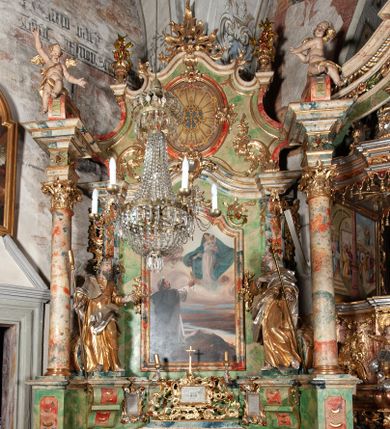 Zdjęcie nr 1: Ołtarz na rzucie połowy owalu, architektoniczny, kulisowy, jednokondygnacyjny, jednoosiowy, ze zwieńczeniem. Drewniana mensa ołtarza (późniejsza) oparta na skrzyni o formie tumby z wydzielonym cokołem. Retabulum na wysokim potrójnym, cokole, ujęte parą ukośnie ustawionych konsol o formie wolut, na których ustawione rzeźby, oraz parą odsuniętych od lica części środkowej kolumn o gładkich trzonach i kompozytowych kapitelach, wspierających przerwane belkowanie i gzyms. Pole środkowe ujęte pilastrami o wolutowych kapitelach, zwieńczone gzymsem wygiętym łukiem wklęsło-wypukłym. Pośrodku pola profilowana rama zamknięta łukiem wklęsło-wypukłym nadwieszonym, na obraz ołtarzowy. Zwieńczenie o dekoracyjnym wykroju linią wklęsło-wypukłą, z  wysuniętymi  na kolumny spływami wolutowymi.  Pośrodku zwieńczenia profilowana rama w kształcie stojącego owalu. Antepedium, część środkowa retabulum oraz zwieńczenie zdobione motywami ornamentów rokokowych. Retabulum ujęte parą ażurowych, rokokowych uszaków. W płycinach na spływach motywy roślinne i rozetki. Pośrodku gzymsu wieńczącego część środkową retabulum kartusz ujęty ornamentem rokokowym. W zwieńczeniu, na gzymsie, po bokach para wazonów z kwiatami, szczyt z dekoracją roccaillową. W polu środkowym obraz Matka Boska Różańcowa ze świętym Dominikiem. Na wolutowych konsolach po bokach rzeźby św. Joachima po lewej i św. Józefa po prawej stronie. W zwieńczeniu malowane splecione litery imienia MARIA, ujęte promienistą glorią oraz wieńcem z róż. W osiach kolumn na spływach wolutowych zwieńczenia para aniołków. Na mensie trzy kanony ołtarzowe ujęte ażurowymi ramami ze stylizowanych wici akantu, zdobione rozetami. Struktura ołtarza w całości marmoryzowana, kolorystyka w odcieniach zieleni, beżów, czerwieni i niebieskim. Fragmenty detalu architektonicznego i ornamenty złocone i srebrzone. 