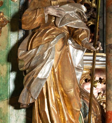 Zdjęcie nr 6: Ołtarz na rzucie połowy owalu, architektoniczny, kulisowy, jednokondygnacyjny, jednoosiowy, ze zwieńczeniem. Drewniana mensa ołtarza (późniejsza) oparta na skrzyni o formie tumby z wydzielonym cokołem. Retabulum na wysokim potrójnym, cokole, ujęte parą ukośnie ustawionych konsol o formie wolut, na których ustawione rzeźby, oraz parą odsuniętych od lica części środkowej kolumn o gładkich trzonach i kompozytowych kapitelach, wspierających przerwane belkowanie i gzyms. Pole środkowe ujęte pilastrami o wolutowych kapitelach, zwieńczone gzymsem wygiętym łukiem wklęsło-wypukłym. Pośrodku pola profilowana rama zamknięta łukiem wklęsło-wypukłym nadwieszonym, na obraz ołtarzowy. Zwieńczenie o dekoracyjnym wykroju linią wklęsło-wypukłą, z  wysuniętymi  na kolumny spływami wolutowymi.  Pośrodku zwieńczenia profilowana rama w kształcie stojącego owalu. Antepedium, część środkowa retabulum oraz zwieńczenie zdobione motywami ornamentów rokokowych. Retabulum ujęte parą ażurowych, rokokowych uszaków. W płycinach na spływach motywy roślinne i rozetki. Pośrodku gzymsu wieńczącego część środkową retabulum kartusz ujęty ornamentem rokokowym. W zwieńczeniu, na gzymsie, po bokach para wazonów z kwiatami, szczyt z dekoracją roccaillową. W polu środkowym obraz Matka Boska Różańcowa ze świętym Dominikiem. Na wolutowych konsolach po bokach rzeźby św. Joachima po lewej i św. Józefa po prawej stronie. W zwieńczeniu malowane splecione litery imienia MARIA, ujęte promienistą glorią oraz wieńcem z róż. W osiach kolumn na spływach wolutowych zwieńczenia para aniołków. Na mensie trzy kanony ołtarzowe ujęte ażurowymi ramami ze stylizowanych wici akantu, zdobione rozetami. Struktura ołtarza w całości marmoryzowana, kolorystyka w odcieniach zieleni, beżów, czerwieni i niebieskim. Fragmenty detalu architektonicznego i ornamenty złocone i srebrzone. 