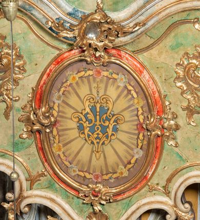 Zdjęcie nr 5: Ołtarz na rzucie połowy owalu, architektoniczny, kulisowy, jednokondygnacyjny, jednoosiowy, ze zwieńczeniem. Drewniana mensa ołtarza (późniejsza) oparta na skrzyni o formie tumby z wydzielonym cokołem. Retabulum na wysokim potrójnym, cokole, ujęte parą ukośnie ustawionych konsol o formie wolut, na których ustawione rzeźby, oraz parą odsuniętych od lica części środkowej kolumn o gładkich trzonach i kompozytowych kapitelach, wspierających przerwane belkowanie i gzyms. Pole środkowe ujęte pilastrami o wolutowych kapitelach, zwieńczone gzymsem wygiętym łukiem wklęsło-wypukłym. Pośrodku pola profilowana rama zamknięta łukiem wklęsło-wypukłym nadwieszonym, na obraz ołtarzowy. Zwieńczenie o dekoracyjnym wykroju linią wklęsło-wypukłą, z  wysuniętymi  na kolumny spływami wolutowymi.  Pośrodku zwieńczenia profilowana rama w kształcie stojącego owalu. Antepedium, część środkowa retabulum oraz zwieńczenie zdobione motywami ornamentów rokokowych. Retabulum ujęte parą ażurowych, rokokowych uszaków. W płycinach na spływach motywy roślinne i rozetki. Pośrodku gzymsu wieńczącego część środkową retabulum kartusz ujęty ornamentem rokokowym. W zwieńczeniu, na gzymsie, po bokach para wazonów z kwiatami, szczyt z dekoracją roccaillową. W polu środkowym obraz Matka Boska Różańcowa ze świętym Dominikiem. Na wolutowych konsolach po bokach rzeźby św. Joachima po lewej i św. Józefa po prawej stronie. W zwieńczeniu malowane splecione litery imienia MARIA, ujęte promienistą glorią oraz wieńcem z róż. W osiach kolumn na spływach wolutowych zwieńczenia para aniołków. Na mensie trzy kanony ołtarzowe ujęte ażurowymi ramami ze stylizowanych wici akantu, zdobione rozetami. Struktura ołtarza w całości marmoryzowana, kolorystyka w odcieniach zieleni, beżów, czerwieni i niebieskim. Fragmenty detalu architektonicznego i ornamenty złocone i srebrzone. 