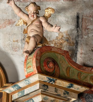 Zdjęcie nr 19: Ołtarz na rzucie połowy owalu, architektoniczny, kulisowy, jednokondygnacyjny, jednoosiowy, ze zwieńczeniem. Drewniana mensa ołtarza (późniejsza) oparta na skrzyni o formie tumby z wydzielonym cokołem. Retabulum na wysokim potrójnym, cokole, ujęte parą ukośnie ustawionych konsol o formie wolut, na których ustawione rzeźby, oraz parą odsuniętych od lica części środkowej kolumn o gładkich trzonach i kompozytowych kapitelach, wspierających przerwane belkowanie i gzyms. Pole środkowe ujęte pilastrami o wolutowych kapitelach, zwieńczone gzymsem wygiętym łukiem wklęsło-wypukłym. Pośrodku pola profilowana rama zamknięta łukiem wklęsło-wypukłym nadwieszonym, na obraz ołtarzowy. Zwieńczenie o dekoracyjnym wykroju linią wklęsło-wypukłą, z  wysuniętymi  na kolumny spływami wolutowymi.  Pośrodku zwieńczenia profilowana rama w kształcie stojącego owalu. Antepedium, część środkowa retabulum oraz zwieńczenie zdobione motywami ornamentów rokokowych. Retabulum ujęte parą ażurowych, rokokowych uszaków. W płycinach na spływach motywy roślinne i rozetki. Pośrodku gzymsu wieńczącego część środkową retabulum kartusz ujęty ornamentem rokokowym. W zwieńczeniu, na gzymsie, po bokach para wazonów z kwiatami, szczyt z dekoracją roccaillową. W polu środkowym obraz Matka Boska Różańcowa ze świętym Dominikiem. Na wolutowych konsolach po bokach rzeźby św. Joachima po lewej i św. Józefa po prawej stronie. W zwieńczeniu malowane splecione litery imienia MARIA, ujęte promienistą glorią oraz wieńcem z róż. W osiach kolumn na spływach wolutowych zwieńczenia para aniołków. Na mensie trzy kanony ołtarzowe ujęte ażurowymi ramami ze stylizowanych wici akantu, zdobione rozetami. Struktura ołtarza w całości marmoryzowana, kolorystyka w odcieniach zieleni, beżów, czerwieni i niebieskim. Fragmenty detalu architektonicznego i ornamenty złocone i srebrzone. 