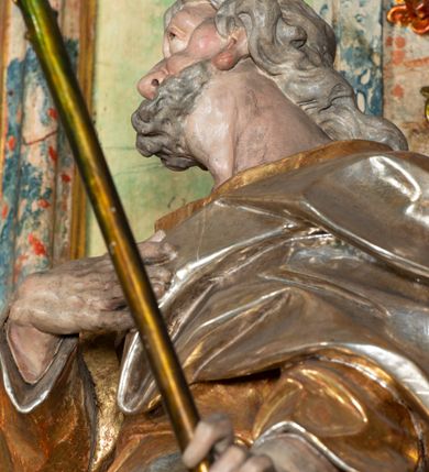 Zdjęcie nr 8: Ołtarz na rzucie połowy owalu, architektoniczny, kulisowy, jednokondygnacyjny, jednoosiowy, ze zwieńczeniem. Drewniana mensa ołtarza (późniejsza) oparta na skrzyni o formie tumby z wydzielonym cokołem. Retabulum na wysokim potrójnym, cokole, ujęte parą ukośnie ustawionych konsol o formie wolut, na których ustawione rzeźby, oraz parą odsuniętych od lica części środkowej kolumn o gładkich trzonach i kompozytowych kapitelach, wspierających przerwane belkowanie i gzyms. Pole środkowe ujęte pilastrami o wolutowych kapitelach, zwieńczone gzymsem wygiętym łukiem wklęsło-wypukłym. Pośrodku pola profilowana rama zamknięta łukiem wklęsło-wypukłym nadwieszonym, na obraz ołtarzowy. Zwieńczenie o dekoracyjnym wykroju linią wklęsło-wypukłą, z  wysuniętymi  na kolumny spływami wolutowymi.  Pośrodku zwieńczenia profilowana rama w kształcie stojącego owalu. Antepedium, część środkowa retabulum oraz zwieńczenie zdobione motywami ornamentów rokokowych. Retabulum ujęte parą ażurowych, rokokowych uszaków. W płycinach na spływach motywy roślinne i rozetki. Pośrodku gzymsu wieńczącego część środkową retabulum kartusz ujęty ornamentem rokokowym. W zwieńczeniu, na gzymsie, po bokach para wazonów z kwiatami, szczyt z dekoracją roccaillową. W polu środkowym obraz Matka Boska Różańcowa ze świętym Dominikiem. Na wolutowych konsolach po bokach rzeźby św. Joachima po lewej i św. Józefa po prawej stronie. W zwieńczeniu malowane splecione litery imienia MARIA, ujęte promienistą glorią oraz wieńcem z róż. W osiach kolumn na spływach wolutowych zwieńczenia para aniołków. Na mensie trzy kanony ołtarzowe ujęte ażurowymi ramami ze stylizowanych wici akantu, zdobione rozetami. Struktura ołtarza w całości marmoryzowana, kolorystyka w odcieniach zieleni, beżów, czerwieni i niebieskim. Fragmenty detalu architektonicznego i ornamenty złocone i srebrzone. 