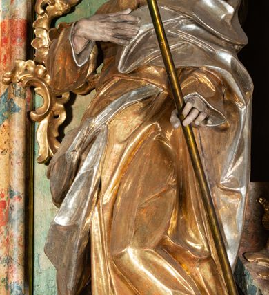 Zdjęcie nr 7: Ołtarz na rzucie połowy owalu, architektoniczny, kulisowy, jednokondygnacyjny, jednoosiowy, ze zwieńczeniem. Drewniana mensa ołtarza (późniejsza) oparta na skrzyni o formie tumby z wydzielonym cokołem. Retabulum na wysokim potrójnym, cokole, ujęte parą ukośnie ustawionych konsol o formie wolut, na których ustawione rzeźby, oraz parą odsuniętych od lica części środkowej kolumn o gładkich trzonach i kompozytowych kapitelach, wspierających przerwane belkowanie i gzyms. Pole środkowe ujęte pilastrami o wolutowych kapitelach, zwieńczone gzymsem wygiętym łukiem wklęsło-wypukłym. Pośrodku pola profilowana rama zamknięta łukiem wklęsło-wypukłym nadwieszonym, na obraz ołtarzowy. Zwieńczenie o dekoracyjnym wykroju linią wklęsło-wypukłą, z  wysuniętymi  na kolumny spływami wolutowymi.  Pośrodku zwieńczenia profilowana rama w kształcie stojącego owalu. Antepedium, część środkowa retabulum oraz zwieńczenie zdobione motywami ornamentów rokokowych. Retabulum ujęte parą ażurowych, rokokowych uszaków. W płycinach na spływach motywy roślinne i rozetki. Pośrodku gzymsu wieńczącego część środkową retabulum kartusz ujęty ornamentem rokokowym. W zwieńczeniu, na gzymsie, po bokach para wazonów z kwiatami, szczyt z dekoracją roccaillową. W polu środkowym obraz Matka Boska Różańcowa ze świętym Dominikiem. Na wolutowych konsolach po bokach rzeźby św. Joachima po lewej i św. Józefa po prawej stronie. W zwieńczeniu malowane splecione litery imienia MARIA, ujęte promienistą glorią oraz wieńcem z róż. W osiach kolumn na spływach wolutowych zwieńczenia para aniołków. Na mensie trzy kanony ołtarzowe ujęte ażurowymi ramami ze stylizowanych wici akantu, zdobione rozetami. Struktura ołtarza w całości marmoryzowana, kolorystyka w odcieniach zieleni, beżów, czerwieni i niebieskim. Fragmenty detalu architektonicznego i ornamenty złocone i srebrzone. 