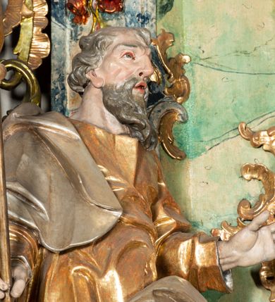 Zdjęcie nr 9: Ołtarz na rzucie połowy owalu, architektoniczny, kulisowy, jednokondygnacyjny, jednoosiowy, ze zwieńczeniem. Drewniana mensa ołtarza (późniejsza) oparta na skrzyni o formie tumby z wydzielonym cokołem. Retabulum na wysokim potrójnym, cokole, ujęte parą ukośnie ustawionych konsol o formie wolut, na których ustawione rzeźby, oraz parą odsuniętych od lica części środkowej kolumn o gładkich trzonach i kompozytowych kapitelach, wspierających przerwane belkowanie i gzyms. Pole środkowe ujęte pilastrami o wolutowych kapitelach, zwieńczone gzymsem wygiętym łukiem wklęsło-wypukłym. Pośrodku pola profilowana rama zamknięta łukiem wklęsło-wypukłym nadwieszonym, na obraz ołtarzowy. Zwieńczenie o dekoracyjnym wykroju linią wklęsło-wypukłą, z  wysuniętymi  na kolumny spływami wolutowymi.  Pośrodku zwieńczenia profilowana rama w kształcie stojącego owalu. Antepedium, część środkowa retabulum oraz zwieńczenie zdobione motywami ornamentów rokokowych. Retabulum ujęte parą ażurowych, rokokowych uszaków. W płycinach na spływach motywy roślinne i rozetki. Pośrodku gzymsu wieńczącego część środkową retabulum kartusz ujęty ornamentem rokokowym. W zwieńczeniu, na gzymsie, po bokach para wazonów z kwiatami, szczyt z dekoracją roccaillową. W polu środkowym obraz Matka Boska Różańcowa ze świętym Dominikiem. Na wolutowych konsolach po bokach rzeźby św. Joachima po lewej i św. Józefa po prawej stronie. W zwieńczeniu malowane splecione litery imienia MARIA, ujęte promienistą glorią oraz wieńcem z róż. W osiach kolumn na spływach wolutowych zwieńczenia para aniołków. Na mensie trzy kanony ołtarzowe ujęte ażurowymi ramami ze stylizowanych wici akantu, zdobione rozetami. Struktura ołtarza w całości marmoryzowana, kolorystyka w odcieniach zieleni, beżów, czerwieni i niebieskim. Fragmenty detalu architektonicznego i ornamenty złocone i srebrzone. 