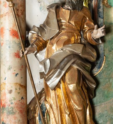 Zdjęcie nr 12: Ołtarz na rzucie połowy owalu, architektoniczny, kulisowy, jednokondygnacyjny, jednoosiowy, ze zwieńczeniem. Drewniana mensa ołtarza (późniejsza) oparta na skrzyni o formie tumby z wydzielonym cokołem. Retabulum na wysokim potrójnym, cokole, ujęte parą ukośnie ustawionych konsol o formie wolut, na których ustawione rzeźby, oraz parą odsuniętych od lica części środkowej kolumn o gładkich trzonach i kompozytowych kapitelach, wspierających przerwane belkowanie i gzyms. Pole środkowe ujęte pilastrami o wolutowych kapitelach, zwieńczone gzymsem wygiętym łukiem wklęsło-wypukłym. Pośrodku pola profilowana rama zamknięta łukiem wklęsło-wypukłym nadwieszonym, na obraz ołtarzowy. Zwieńczenie o dekoracyjnym wykroju linią wklęsło-wypukłą, z  wysuniętymi  na kolumny spływami wolutowymi.  Pośrodku zwieńczenia profilowana rama w kształcie stojącego owalu. Antepedium, część środkowa retabulum oraz zwieńczenie zdobione motywami ornamentów rokokowych. Retabulum ujęte parą ażurowych, rokokowych uszaków. W płycinach na spływach motywy roślinne i rozetki. Pośrodku gzymsu wieńczącego część środkową retabulum kartusz ujęty ornamentem rokokowym. W zwieńczeniu, na gzymsie, po bokach para wazonów z kwiatami, szczyt z dekoracją roccaillową. W polu środkowym obraz Matka Boska Różańcowa ze świętym Dominikiem. Na wolutowych konsolach po bokach rzeźby św. Joachima po lewej i św. Józefa po prawej stronie. W zwieńczeniu malowane splecione litery imienia MARIA, ujęte promienistą glorią oraz wieńcem z róż. W osiach kolumn na spływach wolutowych zwieńczenia para aniołków. Na mensie trzy kanony ołtarzowe ujęte ażurowymi ramami ze stylizowanych wici akantu, zdobione rozetami. Struktura ołtarza w całości marmoryzowana, kolorystyka w odcieniach zieleni, beżów, czerwieni i niebieskim. Fragmenty detalu architektonicznego i ornamenty złocone i srebrzone. 