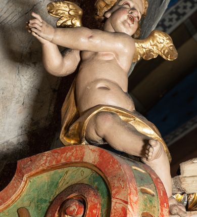 Zdjęcie nr 22: Ołtarz na rzucie połowy owalu, architektoniczny, kulisowy, jednokondygnacyjny, jednoosiowy, ze zwieńczeniem. Drewniana mensa ołtarza (późniejsza) oparta na skrzyni o formie tumby z wydzielonym cokołem. Retabulum na wysokim potrójnym, cokole, ujęte parą ukośnie ustawionych konsol o formie wolut, na których ustawione rzeźby, oraz parą odsuniętych od lica części środkowej kolumn o gładkich trzonach i kompozytowych kapitelach, wspierających przerwane belkowanie i gzyms. Pole środkowe ujęte pilastrami o wolutowych kapitelach, zwieńczone gzymsem wygiętym łukiem wklęsło-wypukłym. Pośrodku pola profilowana rama zamknięta łukiem wklęsło-wypukłym nadwieszonym, na obraz ołtarzowy. Zwieńczenie o dekoracyjnym wykroju linią wklęsło-wypukłą, z  wysuniętymi  na kolumny spływami wolutowymi.  Pośrodku zwieńczenia profilowana rama w kształcie stojącego owalu. Antepedium, część środkowa retabulum oraz zwieńczenie zdobione motywami ornamentów rokokowych. Retabulum ujęte parą ażurowych, rokokowych uszaków. W płycinach na spływach motywy roślinne i rozetki. Pośrodku gzymsu wieńczącego część środkową retabulum kartusz ujęty ornamentem rokokowym. W zwieńczeniu, na gzymsie, po bokach para wazonów z kwiatami, szczyt z dekoracją roccaillową. W polu środkowym obraz Matka Boska Różańcowa ze świętym Dominikiem. Na wolutowych konsolach po bokach rzeźby św. Joachima po lewej i św. Józefa po prawej stronie. W zwieńczeniu malowane splecione litery imienia MARIA, ujęte promienistą glorią oraz wieńcem z róż. W osiach kolumn na spływach wolutowych zwieńczenia para aniołków. Na mensie trzy kanony ołtarzowe ujęte ażurowymi ramami ze stylizowanych wici akantu, zdobione rozetami. Struktura ołtarza w całości marmoryzowana, kolorystyka w odcieniach zieleni, beżów, czerwieni i niebieskim. Fragmenty detalu architektonicznego i ornamenty złocone i srebrzone. 