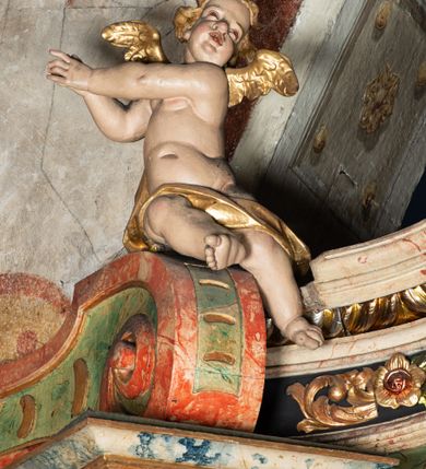 Zdjęcie nr 23: Ołtarz na rzucie połowy owalu, architektoniczny, kulisowy, jednokondygnacyjny, jednoosiowy, ze zwieńczeniem. Drewniana mensa ołtarza (późniejsza) oparta na skrzyni o formie tumby z wydzielonym cokołem. Retabulum na wysokim potrójnym, cokole, ujęte parą ukośnie ustawionych konsol o formie wolut, na których ustawione rzeźby, oraz parą odsuniętych od lica części środkowej kolumn o gładkich trzonach i kompozytowych kapitelach, wspierających przerwane belkowanie i gzyms. Pole środkowe ujęte pilastrami o wolutowych kapitelach, zwieńczone gzymsem wygiętym łukiem wklęsło-wypukłym. Pośrodku pola profilowana rama zamknięta łukiem wklęsło-wypukłym nadwieszonym, na obraz ołtarzowy. Zwieńczenie o dekoracyjnym wykroju linią wklęsło-wypukłą, z  wysuniętymi  na kolumny spływami wolutowymi.  Pośrodku zwieńczenia profilowana rama w kształcie stojącego owalu. Antepedium, część środkowa retabulum oraz zwieńczenie zdobione motywami ornamentów rokokowych. Retabulum ujęte parą ażurowych, rokokowych uszaków. W płycinach na spływach motywy roślinne i rozetki. Pośrodku gzymsu wieńczącego część środkową retabulum kartusz ujęty ornamentem rokokowym. W zwieńczeniu, na gzymsie, po bokach para wazonów z kwiatami, szczyt z dekoracją roccaillową. W polu środkowym obraz Matka Boska Różańcowa ze świętym Dominikiem. Na wolutowych konsolach po bokach rzeźby św. Joachima po lewej i św. Józefa po prawej stronie. W zwieńczeniu malowane splecione litery imienia MARIA, ujęte promienistą glorią oraz wieńcem z róż. W osiach kolumn na spływach wolutowych zwieńczenia para aniołków. Na mensie trzy kanony ołtarzowe ujęte ażurowymi ramami ze stylizowanych wici akantu, zdobione rozetami. Struktura ołtarza w całości marmoryzowana, kolorystyka w odcieniach zieleni, beżów, czerwieni i niebieskim. Fragmenty detalu architektonicznego i ornamenty złocone i srebrzone. 