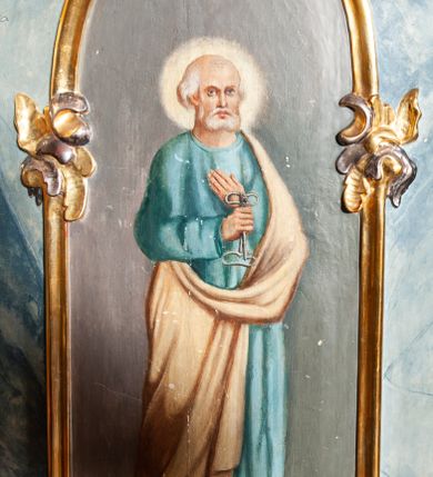 Zdjęcie nr 31: Ołtarz architektoniczny, trójosiowy, z wydzieloną częścią cokołową, jednokondygnacyjny, ze zwieńczeniem. Mensa drewniana tumbowa, ozdobiona nałożonymi płaskorzeźbionymi motywami rocaille’ów i roślinnymi. Po bokach mensy, w części cokołowej dwie bramki obejścia zamknięte półkoliście, w których osadzone na zawiasach drzwi jednoskrzydłowe z płycinami z malowanymi przedstawieniami świętych. W predelli oszklona trumienka z rzeźbą Chrystusa w grobie. Pole środkowe nastawy ujęte dwoma czworobocznymi filarami o kompozytowych kapitelach. Pola boczne wklęsłe i cofnięte od lica pola środkowego flankowane kolumnami o gładkich trzonach i kompozytowych kapitelach, umieszczonych na wysokich dwustopniowych postumentach ustawionych kątowo, zdobionych płycinami. Podpory dźwigają pełne belkowanie i gzyms, przerwane nad polem środkowym. W polu środkowym głęboka nisza w kształcie prostokąta stojącego zamkniętego łukiem wypukło-wklęsłym, w bogatym obramieniu. W niej rzeźba Pieta. Po bokach, na tle filarów, umieszczone dwa okazałe anioły w dynamicznych pozach, z rozłożonymi skrzydłami. Ponad niszą płaskorzeźbiona Chusta św. Weroniki rozpostarta przez dwa uskrzydlone putta ze stopami wspartymi na obłokach. W polach bocznych nastawy sferyczne płyciny w asymetrycznych złoconych obramieniach, na których tle umieszczone na konsolach rzeźby: Św. Jan Ewangelista (po lewej) i Św. Maria Magdalena (po prawej). Zwieńczenie w formie aedikuli ujętej wolutami i zwieńczonej półkoliście. Na tle aedikuli rzeźbione przedstawienie tronującego Boga Ojca, ponad głową którego Arma Christi; wokół putta i uskrzydlone główki aniołków. W osiach podpór rzeźby uskrzydlonych aniołów. Uszaki nastawy rzeźbione, ażurowe, złocone, z motywów rocaille’ów i kwiatów słonecznika. Struktura polichromowana na kolor szaro-niebieski, a trzony filarów i kolumn oraz tła płycin na czerwono, imitując marmur;  detale i ornamenty złocone; szaty rzeźb złocone i srebrzone; karnacje w kolorze naturalnym. 