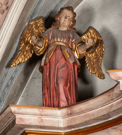 Zdjęcie nr 5: Ołtarz architektoniczny, trójosiowy, z wydzieloną częścią cokołową, jednokondygnacyjny, ze zwieńczeniem. Mensa drewniana tumbowa, ozdobiona nałożonymi płaskorzeźbionymi motywami rocaille’ów i roślinnymi. Po bokach mensy, w części cokołowej dwie bramki obejścia zamknięte półkoliście, w których osadzone na zawiasach drzwi jednoskrzydłowe z płycinami z malowanymi przedstawieniami świętych. W predelli oszklona trumienka z rzeźbą Chrystusa w grobie. Pole środkowe nastawy ujęte dwoma czworobocznymi filarami o kompozytowych kapitelach. Pola boczne wklęsłe i cofnięte od lica pola środkowego flankowane kolumnami o gładkich trzonach i kompozytowych kapitelach, umieszczonych na wysokich dwustopniowych postumentach ustawionych kątowo, zdobionych płycinami. Podpory dźwigają pełne belkowanie i gzyms, przerwane nad polem środkowym. W polu środkowym głęboka nisza w kształcie prostokąta stojącego zamkniętego łukiem wypukło-wklęsłym, w bogatym obramieniu. W niej rzeźba Pieta. Po bokach, na tle filarów, umieszczone dwa okazałe anioły w dynamicznych pozach, z rozłożonymi skrzydłami. Ponad niszą płaskorzeźbiona Chusta św. Weroniki rozpostarta przez dwa uskrzydlone putta ze stopami wspartymi na obłokach. W polach bocznych nastawy sferyczne płyciny w asymetrycznych złoconych obramieniach, na których tle umieszczone na konsolach rzeźby: Św. Jan Ewangelista (po lewej) i Św. Maria Magdalena (po prawej). Zwieńczenie w formie aedikuli ujętej wolutami i zwieńczonej półkoliście. Na tle aedikuli rzeźbione przedstawienie tronującego Boga Ojca, ponad głową którego Arma Christi; wokół putta i uskrzydlone główki aniołków. W osiach podpór rzeźby uskrzydlonych aniołów. Uszaki nastawy rzeźbione, ażurowe, złocone, z motywów rocaille’ów i kwiatów słonecznika. Struktura polichromowana na kolor szaro-niebieski, a trzony filarów i kolumn oraz tła płycin na czerwono, imitując marmur;  detale i ornamenty złocone; szaty rzeźb złocone i srebrzone; karnacje w kolorze naturalnym. 