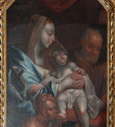 Zdjęcie nr 8: Obraz w kształcie stojącego prostokąta o trójbocznym zwieńczeniu, ujętego srebrzono-złoconą, profilowaną ramą, zdobioną motywem kampanulli, rozetek i roccaillu. Na pierwszym planie siedząca postać Matki Boskiej ukazanej z profilu, do kolan. Maria o jasnej karnacji, ubrana w białą tunikę okrytą niebieskim płaszczem, na głowie jasna chusta. Maria przytula stojące en face na jej kolanach Dzieciątko, okryte białą szatą. Przed Marią ujęta z profilu, do pasa dziecięca postać św. Jana Chrzciciela ubranego w skórę, całującego podtrzymywaną lewą dłonią stopę Jezusa. Prawa dłoń złożona na piersiach. Jezus prawą ręką wskazuje na krzyż wsparty o lewe ramię św. Jana Chrzciciela, przez który przewieszona jest szarfa z napisem: ECCE AGNUS DEI. W tle widoczna postać św. Józefa ukazanego z profilu, zwracającego głowę w stronę Marii i Dzieciątka. W górnej partii obrazu widoczny fragment bordowej draperii. Kolorystyka stonowana, partie szat Marii mocno rozbielone. Karnacje Marii i Dzieciątka sinoblade, św. Jana i św. Józefa śniade. 