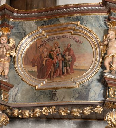 Zdjęcie nr 7: Prospekt organowy jednokondygnacyjny, trójosiowy, złożony z trzech prostopadłościennych segmentów z ryzalitami; środkowy najwyższy, na rzucie półkolisty, skrajne niższe, dwuboczne, dźwigające odcinki belkowania i profilowanego gzymsu; w zwieńczeniu owalne medaliony ujęte liśćmi akantu. Ryzality wypełnione piszczałkami, częściowo przesłoniętymi ażurową dekoracją. Prospekt ujęty ażurowymi uszakami z motywów roślinnych. Struktura polichromowana w kolorze drewna, ornamenty złocone.
