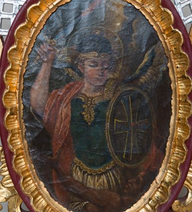 Zdjęcie nr 3: Feretron dwustronny ustawiony na prostopadłościennej podstawie zaopatrzonej w otwory na drążki do noszenia. Podstawa zwężająca się ku górze w formę niskiego cokołu, po bokach dekorowanego szeroką, karbowaną wstęgą. Na cokole osadzona jest owalna rama, dekorowana rocaille’owym fartuchem, w której umieszczony jest wizerunek św. Michała Archanioła, a na odwrociu św. Józefa Kalasantego. Zwieńczenie w formie esowato wygiętej i delikatnie karbowanej wstęgi, zakończonej po bokach dwoma spływami kwiatowymi. Od zewnątrz wstęga ozdobiona jest rocaille’m, a od wewnątrz połączona ze strukturą feretronu srebrzoną kratką. Na awersie obraz św. Michała Archanioła, ukazanego w dynamicznej pozie, strącającego szatana do piekła. Archanioł przedstawiony w postawie stojącej w półpostaci z podniesioną prawą ręką do góry, w której trzyma płomienisty miecz skierowany ostrzem ku górze, a w lewej owalną tarczę ozdobioną znakiem krzyża. Twarz trójkątna, z długim i prostym nosem, wzrokiem skierowanym w dół. Włosy średniej długości, jasne, rozwiane po bokach. Archanioł ubrany jest w zbroję legionisty rzymskiego: ma niebieską tunikę obszytą złotą lamówką na brzegu, hełm i czerwony płaszcz na prawym ramieniu; natomiast na plecach ma złote skrzydła. Na dole kompozycji ukazany jest szatan w pozycji leżącej z głową z prawej strony obrazu, lewą rękę wznoszący ku górze. Twarz podłużna z rogami na czole, karnacja ciemna. Ubrany jest w białą szatę, odsłaniającą nagi tors. Tło obrazu jest jednolite, ciemne, rozjaśnione w górnej części. Wokół głowy św. Michała znajduje się okrągły i złoty nimb. Po drugiej stronie feretronu umieszczony jest obraz św. Józefa Kalasantego. Święty ukazany jest delikatnie z prawej strony kompozycji, zwrócony w prawo w stronę gromadki dzieci. Święty na lewym ramieniu trzyma kilkuletnie dziecko, a prawą głaszcze po głowie nadbiegającego ku niemu chłopca w niebieskiej koszuli i żółtych spodniach. Święty Józef ubrany jest w czarny habit zakonu pijarów. Ma podłużne rysy twarzy z widoczną łysiną i siwymi włosami. Obraz malowany jest w zielono-żółtej tonacji. Tło jasnozielone, rozświetlone w górnej części. Podstawa feretronu malowana farbą olejną w kolorze jasnobrązowym, rama bordowa, detale i ornamentyka złocone i srebrzone. 


