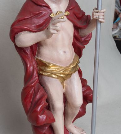 Zdjęcie nr 3: Rzeźba Chrystusa Zmartwychwstałego wolnostojąca, ustawiona na niskim, czarnym cokole o ściętych narożach. Jezus ukazany w całej postaci ustawiony frontalnie na obłoku, w delikatnym kontrapoście z lewą nogą ugiętą w kolanie, prawą ręką uniesioną na wysokość piersi czyni gest błogosławieństwa, w lewej trzyma chorągiew o długim drzewcu, zakończonym złoconym krzyżem oraz z zawieszoną czerwoną tkaniną ze złoconym krzyżem w polu. Chrystus ma podłużną twarz z długim i wąskim nosem, wzrokiem skierowanym w dal, okoloną krótką i ciemną brodą i długimi oraz falowanymi włosami, które opadają na plecy i ramiona. Jest ubrany w złocone perizonium, czerwony płaszcz, spięty pod szyją złotą klamrą, odsłaniający nagi tors, otaczający figurę, silnie drapowany. Na dłoniach, bosych stopach i boku zaznaczone są ślady męki. Polichromia ciała jest naturalistyczna.