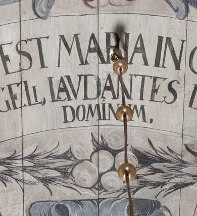 Zdjęcie nr 3: Polichromia umieszczona na stropie nawy głównej. W polu środkowym scena Wniebowzięcia Najświętszej Marii Panny umieszczona w kwadratowej ramie o bokach zamkniętych łukami nadwieszonymi. Rama profilowana, zdobiona rzędem pojedynczych liści. Matka Boska unosząca się na obłokach z szeroko rozłożonymi na boki rękami, prawą wzniesioną do góry. Twarz owalna z długim nosem, silnie zaciśniętymi ustami i dużymi oczami, skierowanymi ku górze. Włosy jasne, kręcone, schowane pod żółtym welonem, którego jeden koniec rozwiany jest wzdłuż prawej ręki. Matka Boska ubrana jest w szeroką, różową suknię, przewiązaną w talii pomarańczową tasiemką oraz błękitny płaszcz, założony za lewe ramię i rozwiany z tyłu. Nad głową Matki Boskiej aniołki unoszą insygnia królewskie: koronę, berło, a także gałązkę białej lilii. Poniżej grupy aniołów podtrzymujące obłoki. Dokoła ramy bujne sploty różnokolorowego akantu przeplecionego karbowaną wstęgą, owijające również ramę ze sceną Wniebowzięcia. W dolnej części ukazane są ponadto dwa anioły podtrzymujące białą wstęgę z napisem: „ASSVMPTA EST MARIA IN COELVM, GAV, / DENT ANGELI, LAVDANTES BENEDICVNT / DOMINVM.” Z kolei z drugiej strony stropu umieszczony jest owalny medalion, obwiedziony liśćmi wawrzynu, w polu którego umieszczone jest czerwone godło zakonu Bożogrobowców oraz małe uskrzydlone główki aniołków. Powyżej na białej wstędze umieszczony jest napis: „SVB HOC SIGNO.”, a poniżej: „RESTAVRATVM A(NN)O (DOMINI) 1714 / Die 14 Aug(st)”. Całość stropu obwiedziona jest dookoła pasem przeważnie prostokątnych kasetonów, wypełnionych różnokolorowymi liśćmi akantu, a także od zewnątrz szerokim pasem dekoracyjnym z brązowych liści wawrzynu. Pasy na bokach wyłamane półkolistymi wypustkami, w których umieszczone są duże muszle palmetowe. Kolorystyka stonowana, jasna z przewagą błękitu i czerwieni.