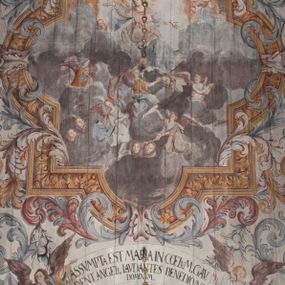 Zdjęcie nr 1: Polichromia umieszczona na stropie nawy głównej. W polu środkowym scena Wniebowzięcia Najświętszej Marii Panny umieszczona w kwadratowej ramie o bokach zamkniętych łukami nadwieszonymi. Rama profilowana, zdobiona rzędem pojedynczych liści. Matka Boska unosząca się na obłokach z szeroko rozłożonymi na boki rękami, prawą wzniesioną do góry. Twarz owalna z długim nosem, silnie zaciśniętymi ustami i dużymi oczami, skierowanymi ku górze. Włosy jasne, kręcone, schowane pod żółtym welonem, którego jeden koniec rozwiany jest wzdłuż prawej ręki. Matka Boska ubrana jest w szeroką, różową suknię, przewiązaną w talii pomarańczową tasiemką oraz błękitny płaszcz, założony za lewe ramię i rozwiany z tyłu. Nad głową Matki Boskiej aniołki unoszą insygnia królewskie: koronę, berło, a także gałązkę białej lilii. Poniżej grupy aniołów podtrzymujące obłoki. Dokoła ramy bujne sploty różnokolorowego akantu przeplecionego karbowaną wstęgą, owijające również ramę ze sceną Wniebowzięcia. W dolnej części ukazane są ponadto dwa anioły podtrzymujące białą wstęgę z napisem: „ASSVMPTA EST MARIA IN COELVM, GAV, / DENT ANGELI, LAVDANTES BENEDICVNT / DOMINVM.” Z kolei z drugiej strony stropu umieszczony jest owalny medalion, obwiedziony liśćmi wawrzynu, w polu którego umieszczone jest czerwone godło zakonu Bożogrobowców oraz małe uskrzydlone główki aniołków. Powyżej na białej wstędze umieszczony jest napis: „SVB HOC SIGNO.”, a poniżej: „RESTAVRATVM A(NN)O (DOMINI) 1714 / Die 14 Aug(st)”. Całość stropu obwiedziona jest dookoła pasem przeważnie prostokątnych kasetonów, wypełnionych różnokolorowymi liśćmi akantu, a także od zewnątrz szerokim pasem dekoracyjnym z brązowych liści wawrzynu. Pasy na bokach wyłamane półkolistymi wypustkami, w których umieszczone są duże muszle palmetowe. Kolorystyka stonowana, jasna z przewagą błękitu i czerwieni.