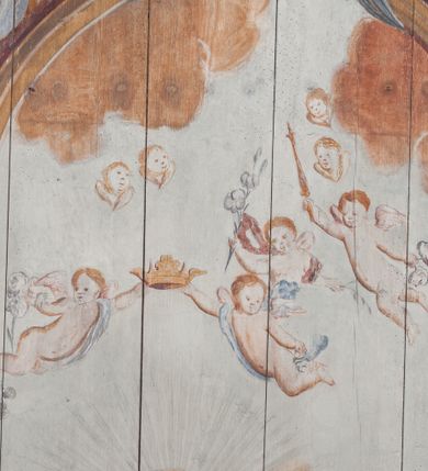 Zdjęcie nr 7: Polichromia umieszczona na stropie nawy głównej. W polu środkowym scena Wniebowzięcia Najświętszej Marii Panny umieszczona w kwadratowej ramie o bokach zamkniętych łukami nadwieszonymi. Rama profilowana, zdobiona rzędem pojedynczych liści. Matka Boska unosząca się na obłokach z szeroko rozłożonymi na boki rękami, prawą wzniesioną do góry. Twarz owalna z długim nosem, silnie zaciśniętymi ustami i dużymi oczami, skierowanymi ku górze. Włosy jasne, kręcone, schowane pod żółtym welonem, którego jeden koniec rozwiany jest wzdłuż prawej ręki. Matka Boska ubrana jest w szeroką, różową suknię, przewiązaną w talii pomarańczową tasiemką oraz błękitny płaszcz, założony za lewe ramię i rozwiany z tyłu. Nad głową Matki Boskiej aniołki unoszą insygnia królewskie: koronę, berło, a także gałązkę białej lilii. Poniżej grupy aniołów podtrzymujące obłoki. Dokoła ramy bujne sploty różnokolorowego akantu przeplecionego karbowaną wstęgą, owijające również ramę ze sceną Wniebowzięcia. W dolnej części ukazane są ponadto dwa anioły podtrzymujące białą wstęgę z napisem: „ASSVMPTA EST MARIA IN COELVM, GAV, / DENT ANGELI, LAVDANTES BENEDICVNT / DOMINVM.” Z kolei z drugiej strony stropu umieszczony jest owalny medalion, obwiedziony liśćmi wawrzynu, w polu którego umieszczone jest czerwone godło zakonu Bożogrobowców oraz małe uskrzydlone główki aniołków. Powyżej na białej wstędze umieszczony jest napis: „SVB HOC SIGNO.”, a poniżej: „RESTAVRATVM A(NN)O (DOMINI) 1714 / Die 14 Aug(st)”. Całość stropu obwiedziona jest dookoła pasem przeważnie prostokątnych kasetonów, wypełnionych różnokolorowymi liśćmi akantu, a także od zewnątrz szerokim pasem dekoracyjnym z brązowych liści wawrzynu. Pasy na bokach wyłamane półkolistymi wypustkami, w których umieszczone są duże muszle palmetowe. Kolorystyka stonowana, jasna z przewagą błękitu i czerwieni.