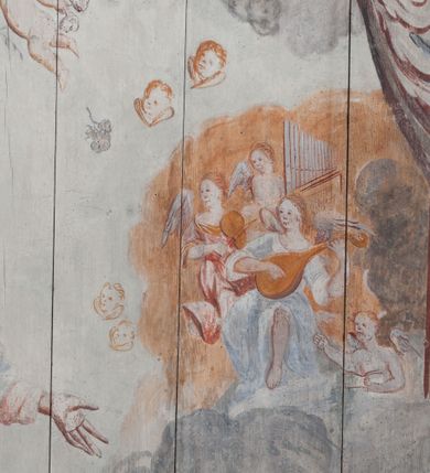 Zdjęcie nr 8: Polichromia umieszczona na stropie nawy głównej. W polu środkowym scena Wniebowzięcia Najświętszej Marii Panny umieszczona w kwadratowej ramie o bokach zamkniętych łukami nadwieszonymi. Rama profilowana, zdobiona rzędem pojedynczych liści. Matka Boska unosząca się na obłokach z szeroko rozłożonymi na boki rękami, prawą wzniesioną do góry. Twarz owalna z długim nosem, silnie zaciśniętymi ustami i dużymi oczami, skierowanymi ku górze. Włosy jasne, kręcone, schowane pod żółtym welonem, którego jeden koniec rozwiany jest wzdłuż prawej ręki. Matka Boska ubrana jest w szeroką, różową suknię, przewiązaną w talii pomarańczową tasiemką oraz błękitny płaszcz, założony za lewe ramię i rozwiany z tyłu. Nad głową Matki Boskiej aniołki unoszą insygnia królewskie: koronę, berło, a także gałązkę białej lilii. Poniżej grupy aniołów podtrzymujące obłoki. Dokoła ramy bujne sploty różnokolorowego akantu przeplecionego karbowaną wstęgą, owijające również ramę ze sceną Wniebowzięcia. W dolnej części ukazane są ponadto dwa anioły podtrzymujące białą wstęgę z napisem: „ASSVMPTA EST MARIA IN COELVM, GAV, / DENT ANGELI, LAVDANTES BENEDICVNT / DOMINVM.” Z kolei z drugiej strony stropu umieszczony jest owalny medalion, obwiedziony liśćmi wawrzynu, w polu którego umieszczone jest czerwone godło zakonu Bożogrobowców oraz małe uskrzydlone główki aniołków. Powyżej na białej wstędze umieszczony jest napis: „SVB HOC SIGNO.”, a poniżej: „RESTAVRATVM A(NN)O (DOMINI) 1714 / Die 14 Aug(st)”. Całość stropu obwiedziona jest dookoła pasem przeważnie prostokątnych kasetonów, wypełnionych różnokolorowymi liśćmi akantu, a także od zewnątrz szerokim pasem dekoracyjnym z brązowych liści wawrzynu. Pasy na bokach wyłamane półkolistymi wypustkami, w których umieszczone są duże muszle palmetowe. Kolorystyka stonowana, jasna z przewagą błękitu i czerwieni.