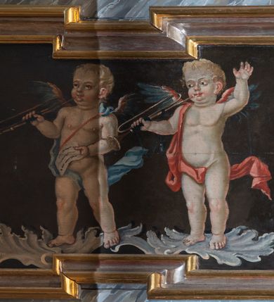 Zdjęcie nr 3: Balustrada chóru muzycznego o wklęsło-wypukłym zarysie, wybrzuszona w środkowej części, z cokołem i podwieszonym lambrekinem. Pola balustrady wydzielone pilastrami, o trzonach mających formę spływów wolutowych, dźwigającymi pełne, przełamane ponad nimi belkowanie, na którym, na osiach podpór, znajdują się kule. Cokół dekorowany rocaille&#039;em i rozetami, a trzony pilastrów kampanulami. W polach znajdują się płyciny z malowanymi scenami. Scena środkowa przedstawia św. Cecylię grającą na organach we wnętrzu z oknem, ujętym filarami. Nad płyciną w partii fryzu belkowania i pod belkowaniem malowane banderole z napisami „Artes cum mundo cunctae pereunte peribunt,” i „In Coelum remeans musica sola manet.”, pod płyciną data „1771”. W czterech pionowych płycinach flankujących pole środkowe znajduje się płaskorzeźbiony rocaille. W pozostałych czterech poziomych płycinach malowane przedstawienia par muzykujących puttów stojących na rocaille&#039;u. Polichromia balustrady imitująca marmur w kolorze szaro-niebieskim z marmoryzowanymi na czerwono profilami, ornamentyka i ramy płycin złocone i srebrzone.