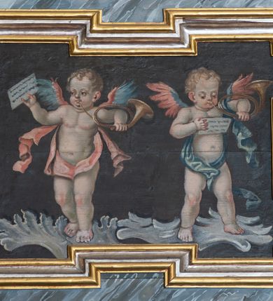 Zdjęcie nr 4: Balustrada chóru muzycznego o wklęsło-wypukłym zarysie, wybrzuszona w środkowej części, z cokołem i podwieszonym lambrekinem. Pola balustrady wydzielone pilastrami, o trzonach mających formę spływów wolutowych, dźwigającymi pełne, przełamane ponad nimi belkowanie, na którym, na osiach podpór, znajdują się kule. Cokół dekorowany rocaille&#039;em i rozetami, a trzony pilastrów kampanulami. W polach znajdują się płyciny z malowanymi scenami. Scena środkowa przedstawia św. Cecylię grającą na organach we wnętrzu z oknem, ujętym filarami. Nad płyciną w partii fryzu belkowania i pod belkowaniem malowane banderole z napisami „Artes cum mundo cunctae pereunte peribunt,” i „In Coelum remeans musica sola manet.”, pod płyciną data „1771”. W czterech pionowych płycinach flankujących pole środkowe znajduje się płaskorzeźbiony rocaille. W pozostałych czterech poziomych płycinach malowane przedstawienia par muzykujących puttów stojących na rocaille&#039;u. Polichromia balustrady imitująca marmur w kolorze szaro-niebieskim z marmoryzowanymi na czerwono profilami, ornamentyka i ramy płycin złocone i srebrzone.