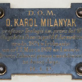 Zdjęcie nr 1: Płyta w formie leżącego prostokąta z czterema uszakami w narożach, przytwierdzona do ściany czterema metalowymi, okrągłymi guzami. W polu złocona inskrypcja: „D(EO) O(PTIMO) M(AXIMO) / O(JCIEC) KAROL MILANYAK / profesor Teologii św(iętej) przez lat 40 / długoletni Prowincyał O.O. Karmelitów / urodz(ony) 1824 we Fridmanie / umarł 2. Marca 1899 we Lwowie / Bracia Zakonni proszą o westchnienie / za duszę Jego. / R(EQUIESCAT) I(N) P(ACE)”. 
