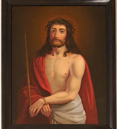 Zdjęcie nr 1: Obraz w formie stojącego prostokąta. W centrum Chrystus ukazany do bioder, zwrócony w trzech czwartych w prawo, ze skrzyżowanymi z przodu dłońmi, związanymi w nadgarstkach powrozem; w lewej dłoni trzyma trzcinę. Twarz ma kwadratową, o zaróżowionych policzkach, dużych, migdałowatych oczach, lekko garbatym nosie i pełnych ustach; okoloną krótką, puszystą brodą oraz brązowymi, lekko kręconymi włosami, opadającymi na ramiona. Na głowie ma koronę cierniową, spod której spływają strużki krwi. Chrystus w partii bioder przewiązany białym, drapowanym perizonium, na prawe ramię ma narzucony czerwony płaszcz. Ma odsłonięty, muskularny tors. Postać ukazana na brązowym tle, rozjaśnionym wokół jej głowy. Obraz ujęty czarną, prostą ramą. 