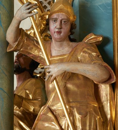 Zdjęcie nr 14: Ołtarz drewniany, prostopadłościenny z drewnianą mensą, w polu antepedium malowana na drewnie scena Zwiastowania (kopia obrazu Leonarda da Vinci). Na ołtarzu stoi tabliczka z kanonem w otoczeniu akantowych wolut tworzących podstawę dla pięciu lichtarzy utworzonych z ornamentu roślinnego. 
Nastawa architektoniczna, jednoosiowa, jednokondygnacyjna ze zwieńczeniem, ustawiona na dwustrefowym cokole, ujęta parą półfilarów i stojącą przed nimi parą kolumn dźwigających pełne belkowanie, przerwane nad polem środkowym. Na cokołach kolumn kanony w ornamentalnych ramach. Kolumny flankują od zewnątrz figury św. Tomasza (?) i św. Jana Nepomucena, od wewnątrz św. Michała Archanioła i św. Jerzego. W polu głównym obraz Matki Boskiej Szkaplerznej w formie stojącego prostokąta zamkniętego łukiem półkolistym nadwieszonym z uskokiem w profilowanej, dekorowanej ornamentem roślinnym ramie. Ponad nim kartusz ujęty ornamentem rocaille'owym i kratką regencyjną oraz uskrzydloną główką anielską flankowaną rocaille'ami. Zwieńczenie w formie leżącego prostokąta ujętego spływami wolutowymi dekorowanymi rocaille'ami, zamkniętego fragmentem falującego gzymsu z monogramem Marii w otoku z obłoków w glorii promienistej. W polu rzeźbiarskie przedstawienie św. Katarzyny Aleksandryjskiej flankowanej obłokami i wiązkami promieni oraz parą puttów. Na belkowaniu figury św. Rozalii i św. Calamindy. Ołtarz ujęty uszami utworzonymi z ornamentu rocaille'owego i kratki regencyjnej. Struktura polichromowana w sposób naśladujący marmoryzację w kolorze niebiesko-białym, profile i ornamentyka pozłacane.