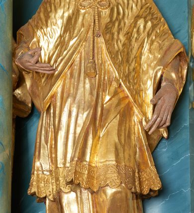 Zdjęcie nr 1: Figura ścięta z tyłu, drążona, zwrócona frontalnie, z głową skierowaną w prawo, w kontrapoście. Święty unosi ugiętą prawą rękę przed klatkę piersiową, lewą opuszcza w dół. 
Twarz ma pociągłą o zapadniętych policzkach, oczach migdałowatych, nosie lekko zgarbionym, ustach pełnych, okoloną wąsami, krótką brodą skręconą w dwa pukle oraz krótkich włosach. Święty jest ubrany w komżę i almucję. Ciało polichromowane naturalistycznie, szaty pozłocone.