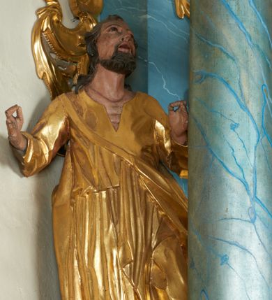 Zdjęcie nr 1: Rzeźba ścięta z tyłu, drążona, zwrócona frontalnie, z uniesioną głową, lewa noga lekko ugięta i cofnięta, obie ręce uniesione i rozłożone na boki. Twarz świętego pociągła o zapadniętych policzkach, migdałowatych oczach, lekko garbatym nosie, otwartych ustach, okolona wąsami i krótką brodą oraz kręconymi włosami sięgającymi ramion. Święty ubrany jest w długą tunikę, przewiązaną w talii, z dużym dekoltem oraz płaszcz zawieszony na taśmie, opadający na jego lewy bok. Ciało polichromowane naturalistycznie, szaty pozłacane. 