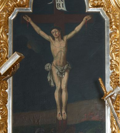 Zdjęcie nr 8: Ołtarz drewniany, prostopadłościenny z drewnianą mensą, w polu antepedium malowana na drewnie scena Ukrzyżowania. Na ołtarzu stoi tabliczka z kanonem w otoczeniu akantowych wolut tworzących podstawę dla pięciu lichtarzy utworzonych z ornamentu roślinnego (brak środkowego). 
Nastawa architektoniczna, jednoosiowa, jednokondygnacyjna ze zwieńczeniem, ustawiona na dwustrefowym cokole, ujęta parą półfilarów i stojącą przed nimi parą kolumn dźwigających pełne belkowanie, przerwane nad polem środkowym. Na cokołach kolumn kanony w ornamentalnych ramach. Kolumny flankują od zewnątrz figury św. Floriana i św. Longina, od wewnątrz św. Donata i św. Marcina. W polu głównym obraz Ukrzyżowania w formie stojącego prostokąta zamkniętego łukiem półkolistym nadwieszonym z uskokiem w profilowanej, dekorowanej ornamentem roślinnym ramie. Ponad nim kartusz ujęty ornamentem rocaille'owym i kratką regencyjną oraz uskrzydlona główka anielska flankowana rocaille'ami. Zwieńczenie w formie leżącego prostokąta ujętego spływami wolutowymi dekorowanymi rocaille'ami, zamkniętego fragmentem falującego gzymsu z monogramem IHS w otoku z obłoków w glorii promienistej. W polu rzeźbiarskie przedstawienie św. Antoniego Padewskiego flankowanego obłokami i wiązkami promieni oraz parą puttów. Na belkowaniu figury św. Walentego i św. Jana Chryzostoma. Ołtarz ujęty uszami utworzonymi z ornamentu rocaille'owego i kratki regencyjnej. Struktura polichromowana w sposób naśladujący marmoryzację w kolorze niebiesko-białym, profile i ornamentyka pozłacane.